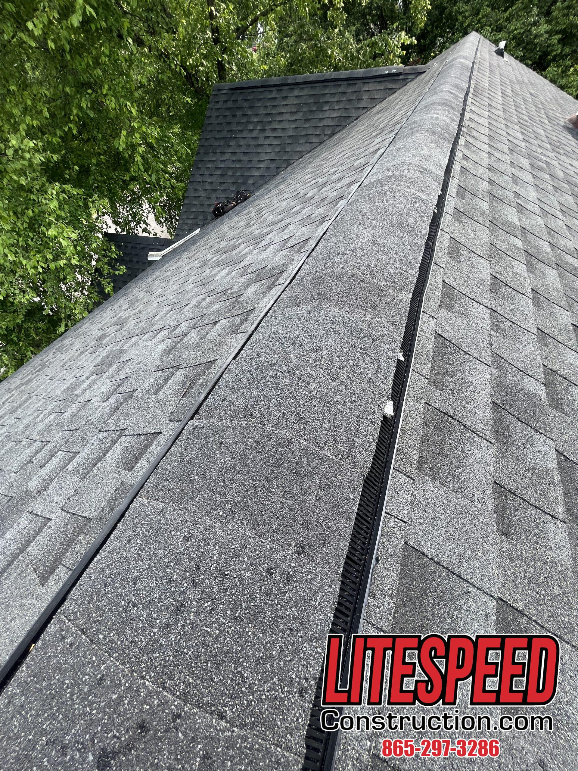 This is a picture of ridge vent with black shingles over it