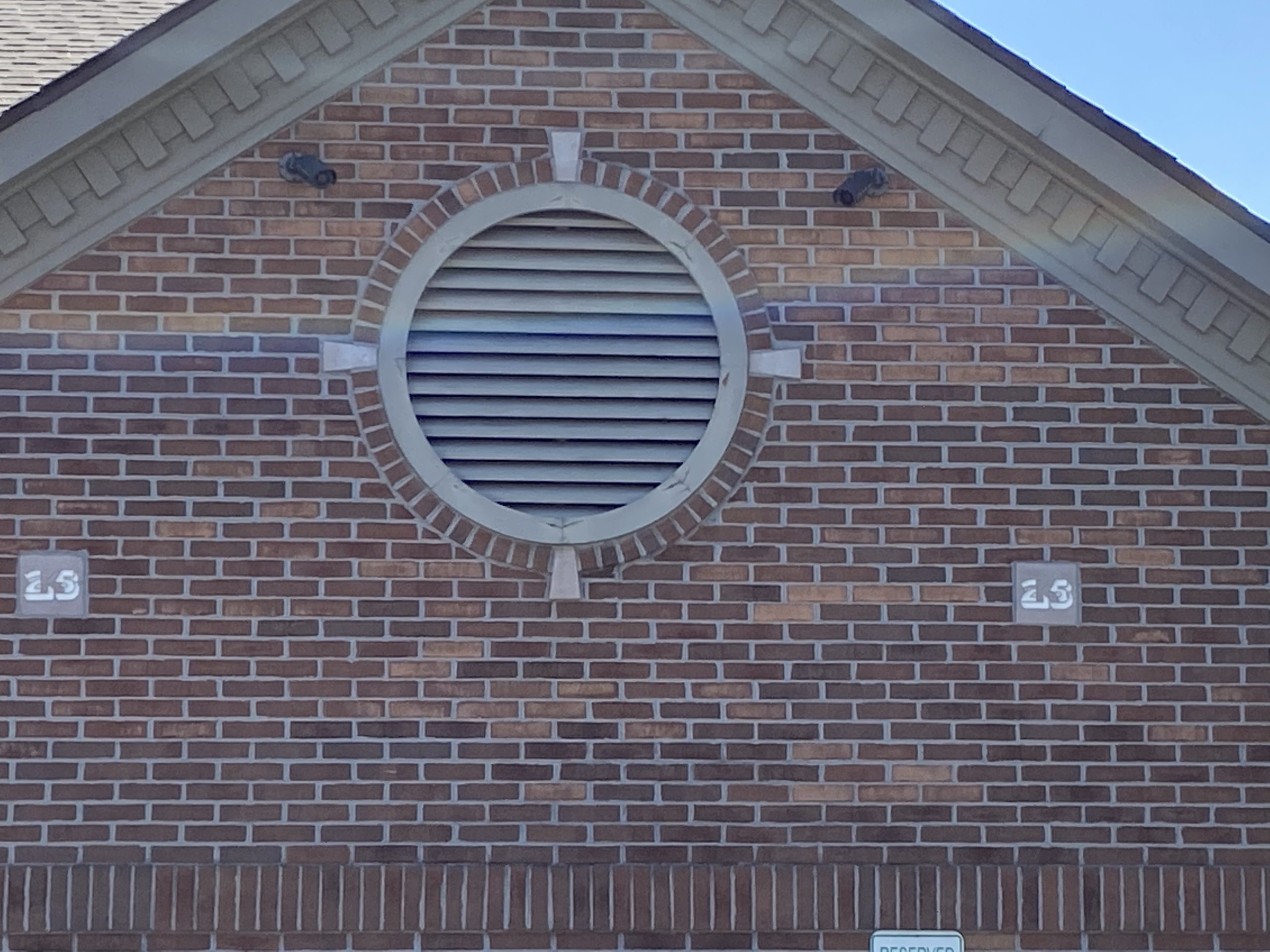 This is a circular gable vent on a brick building.