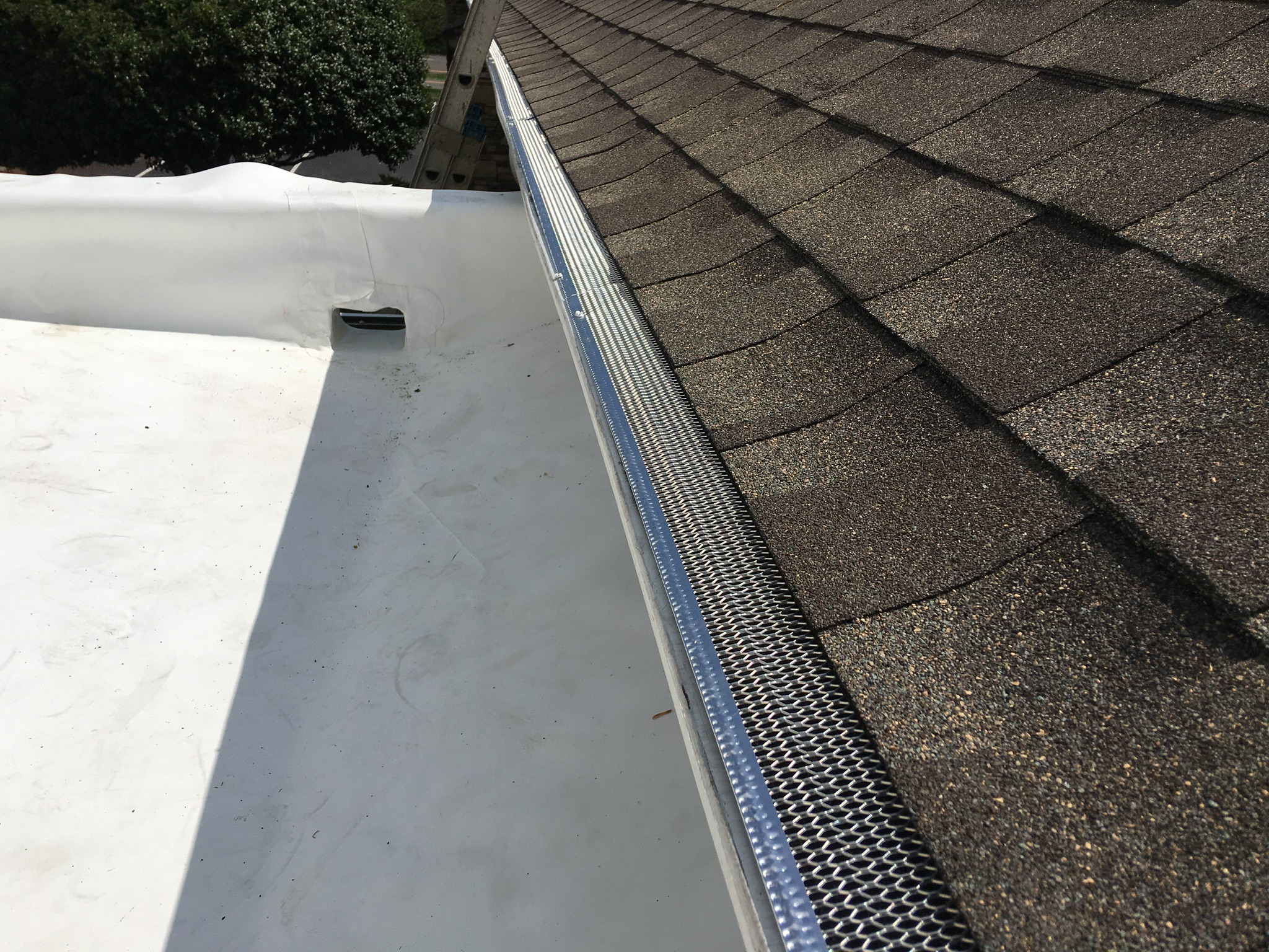 This is a view of white TPO membrane roof installed and the drain cut out.