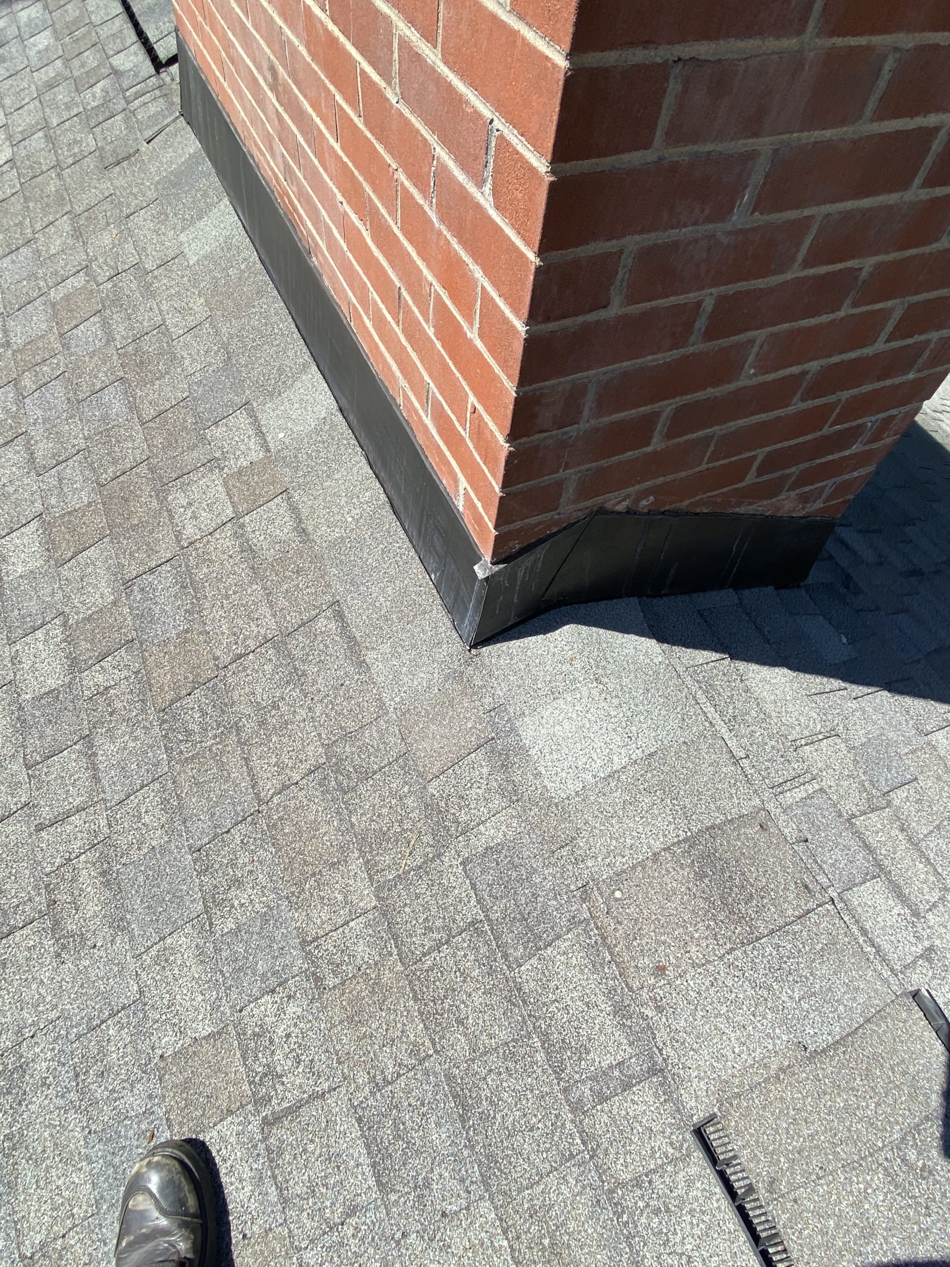 This is an image of bronzed colored chimney flashing on red brick.