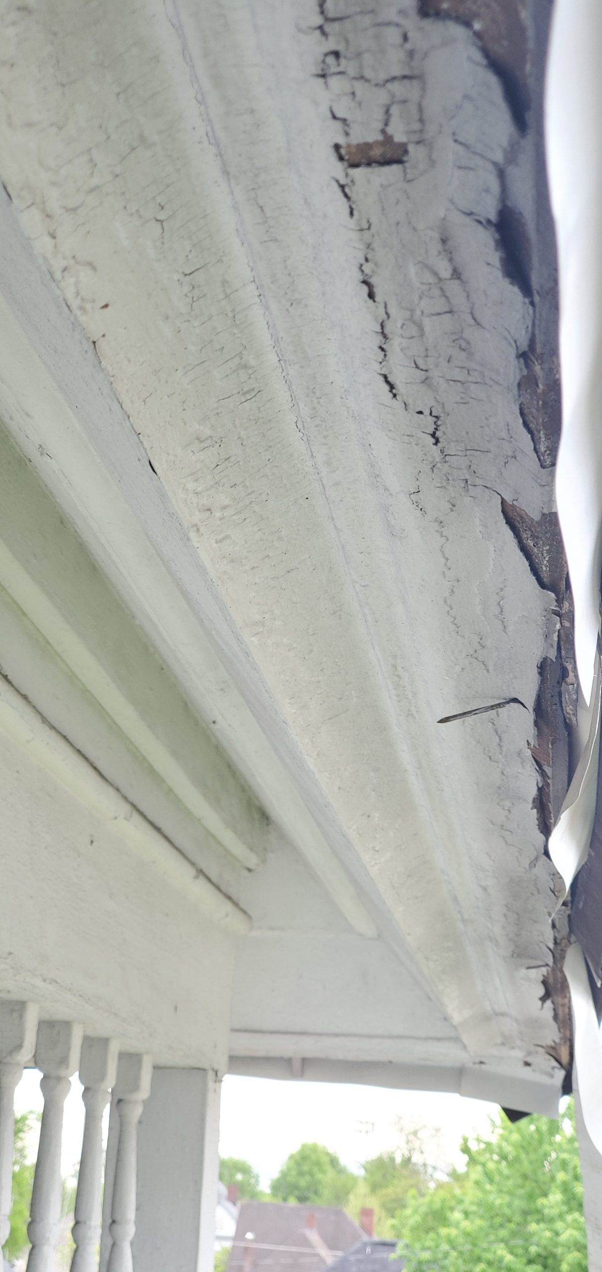 This is a view of white drip edge that is dented and falling off. 