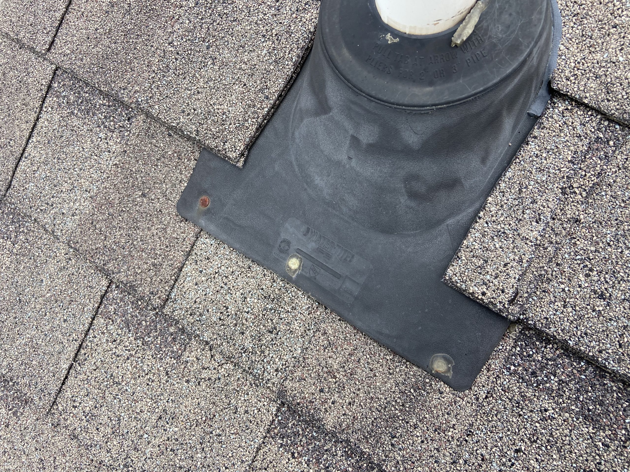 this is a picture of rusty nails on a roof that are holding down a pipe boot