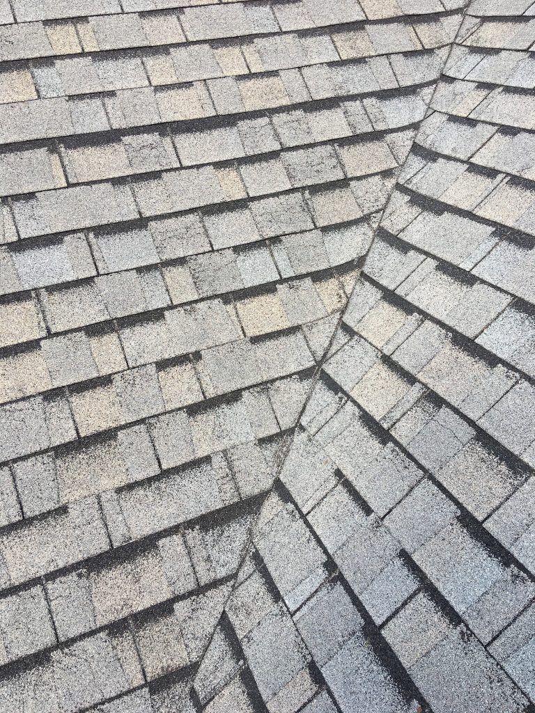 This is a view of 3 tab shingles in gray with hail damage. 
