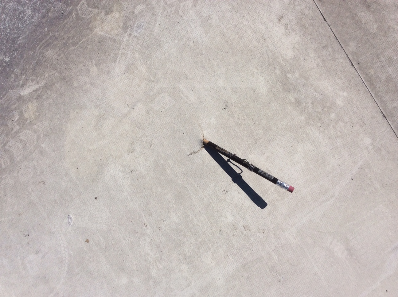 This is a TPO white flat roofing with a hole demonstrated with the end of a pencil in it. 