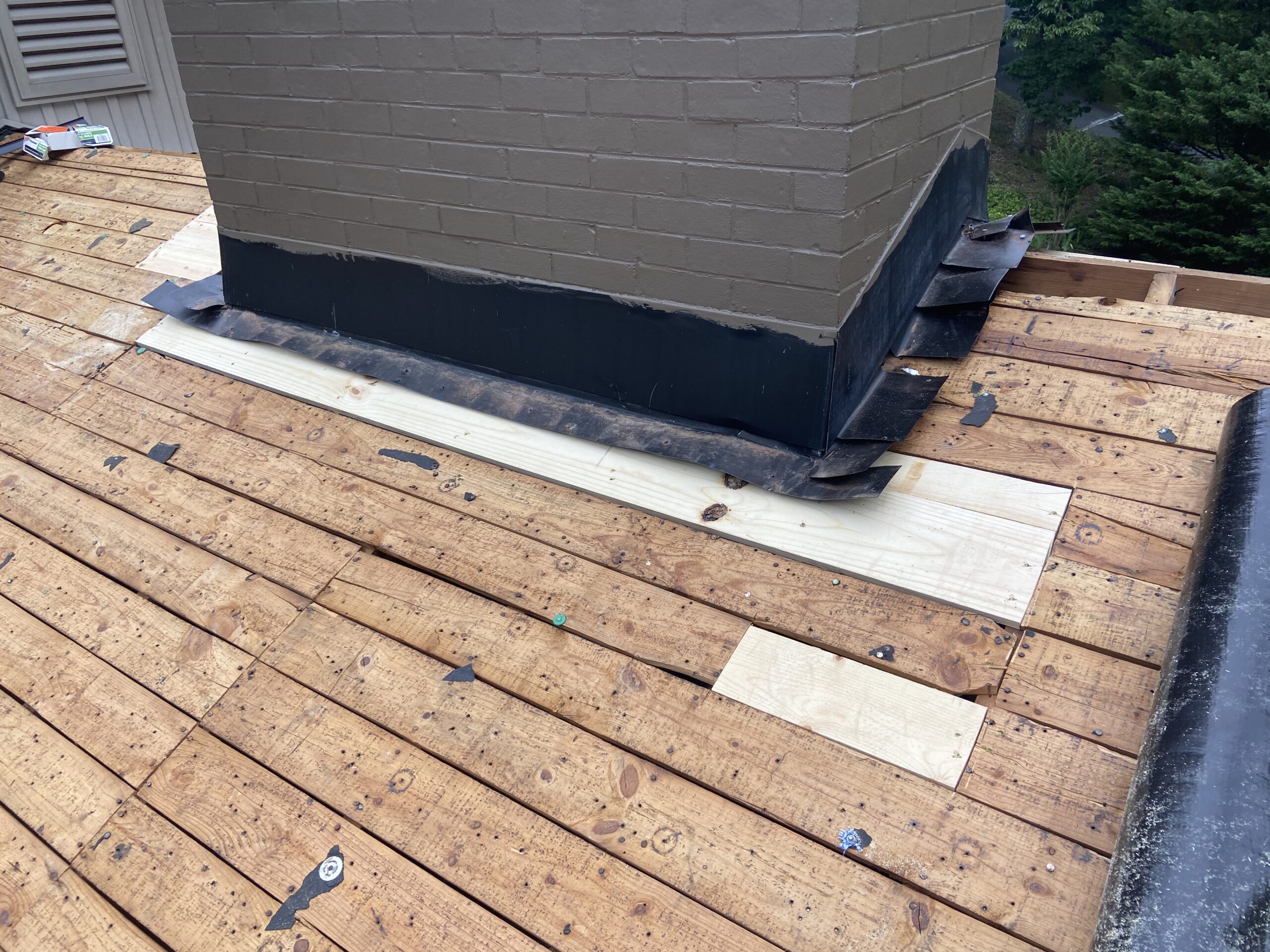 This is an up close view of deck boards and chimney flashing. 