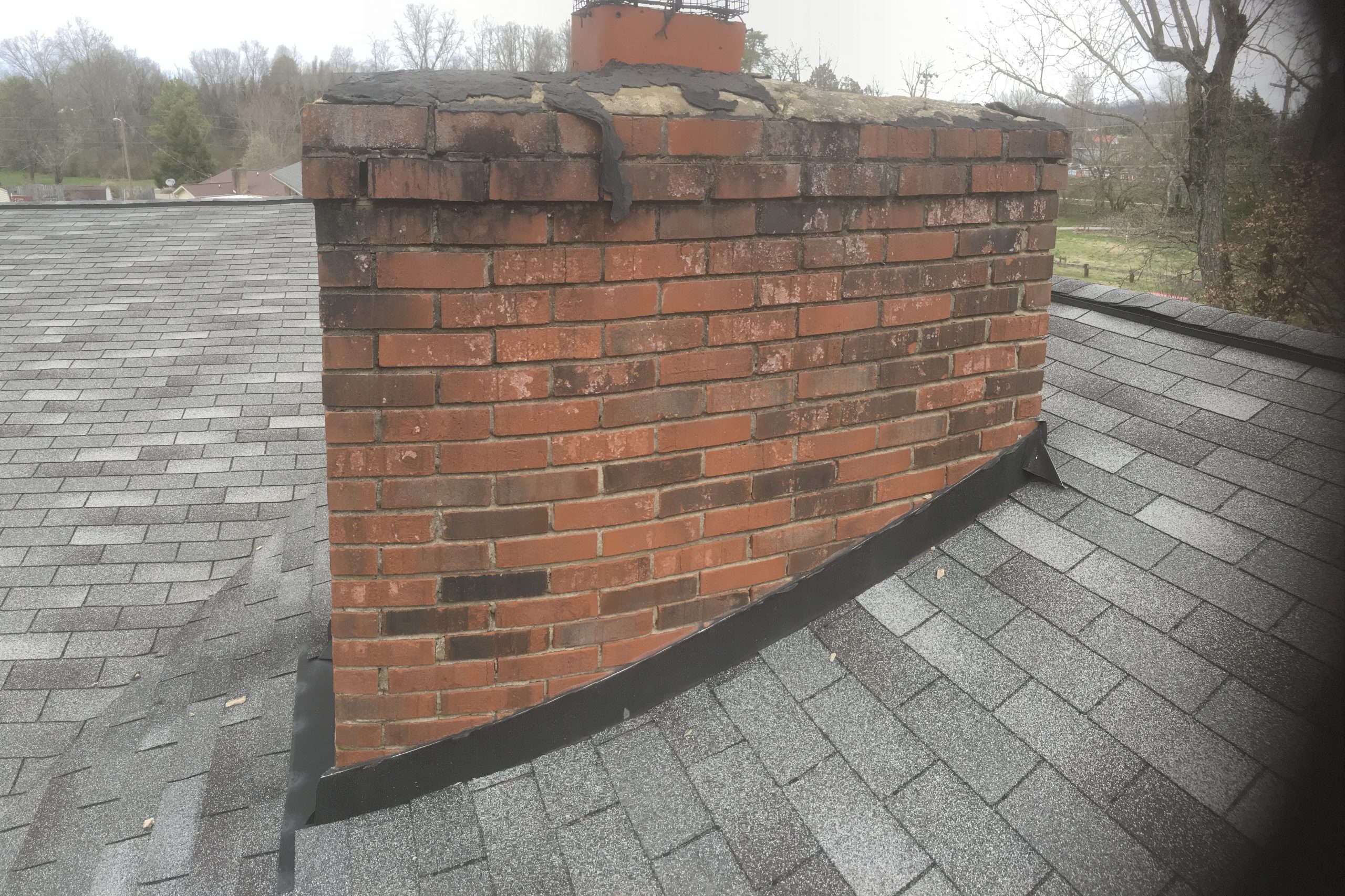 the chimney cap is the cause of this roof leak it is not caused by the shingles or the flashing