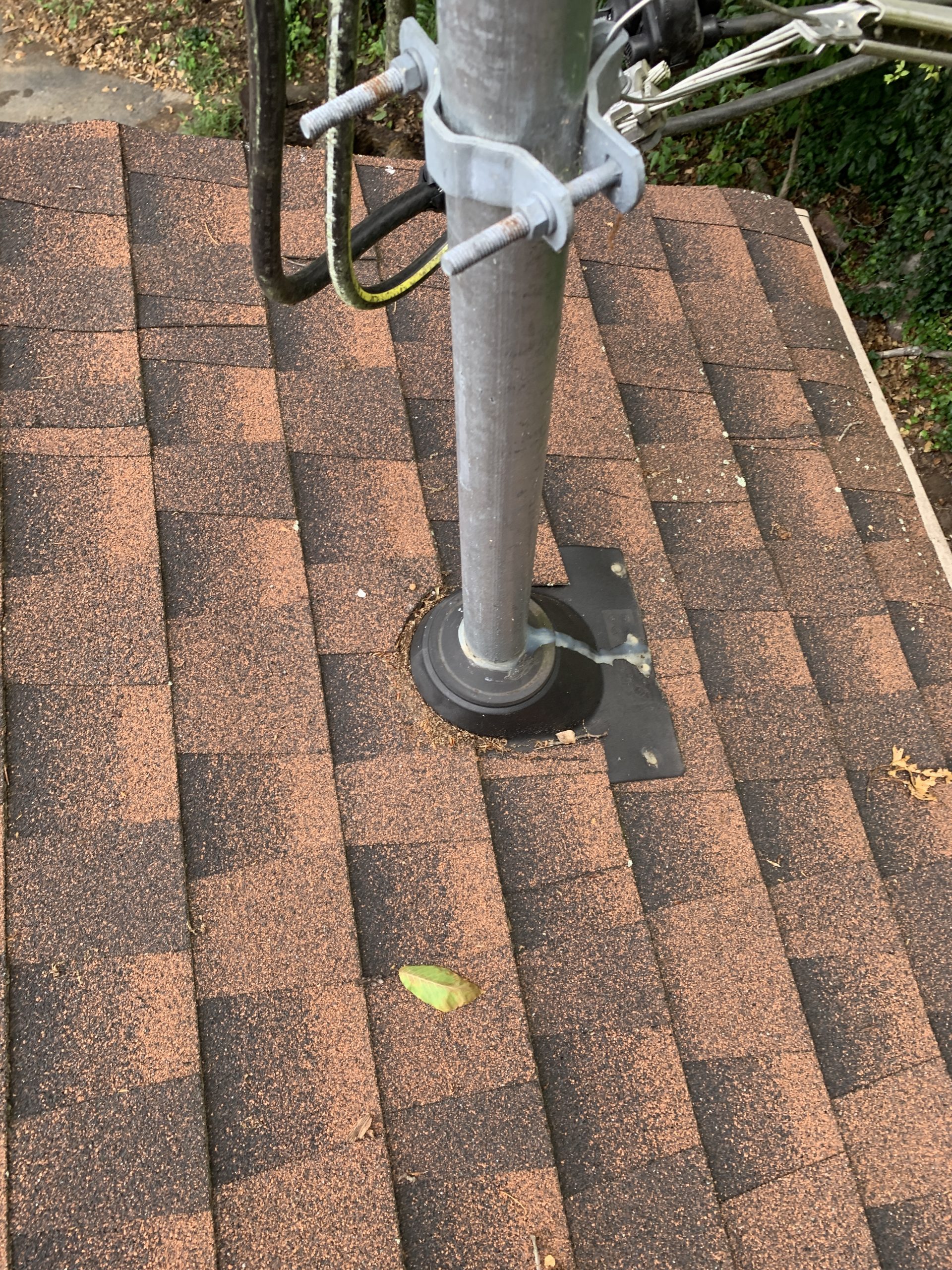 this is a picture of an electrical mast arm that is coming out of a roof and there is a pipe boot that keeps the water out