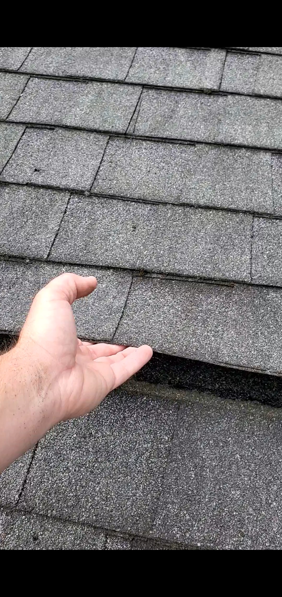 This is a picture of worn out shingles that are lifting. 