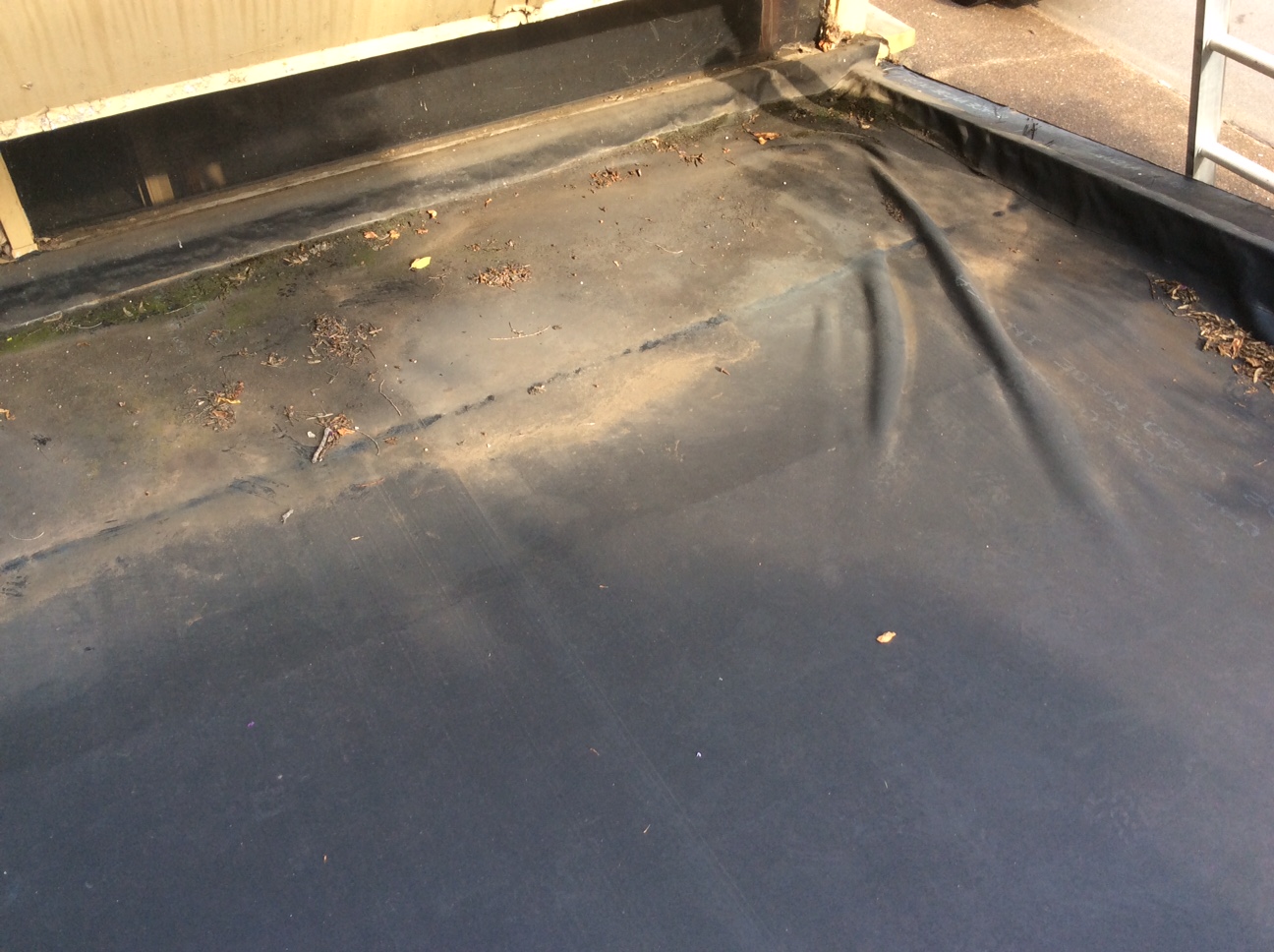 this is a picture of the corner of an old epdm commercial roof that has wrinkles in the rubber roof