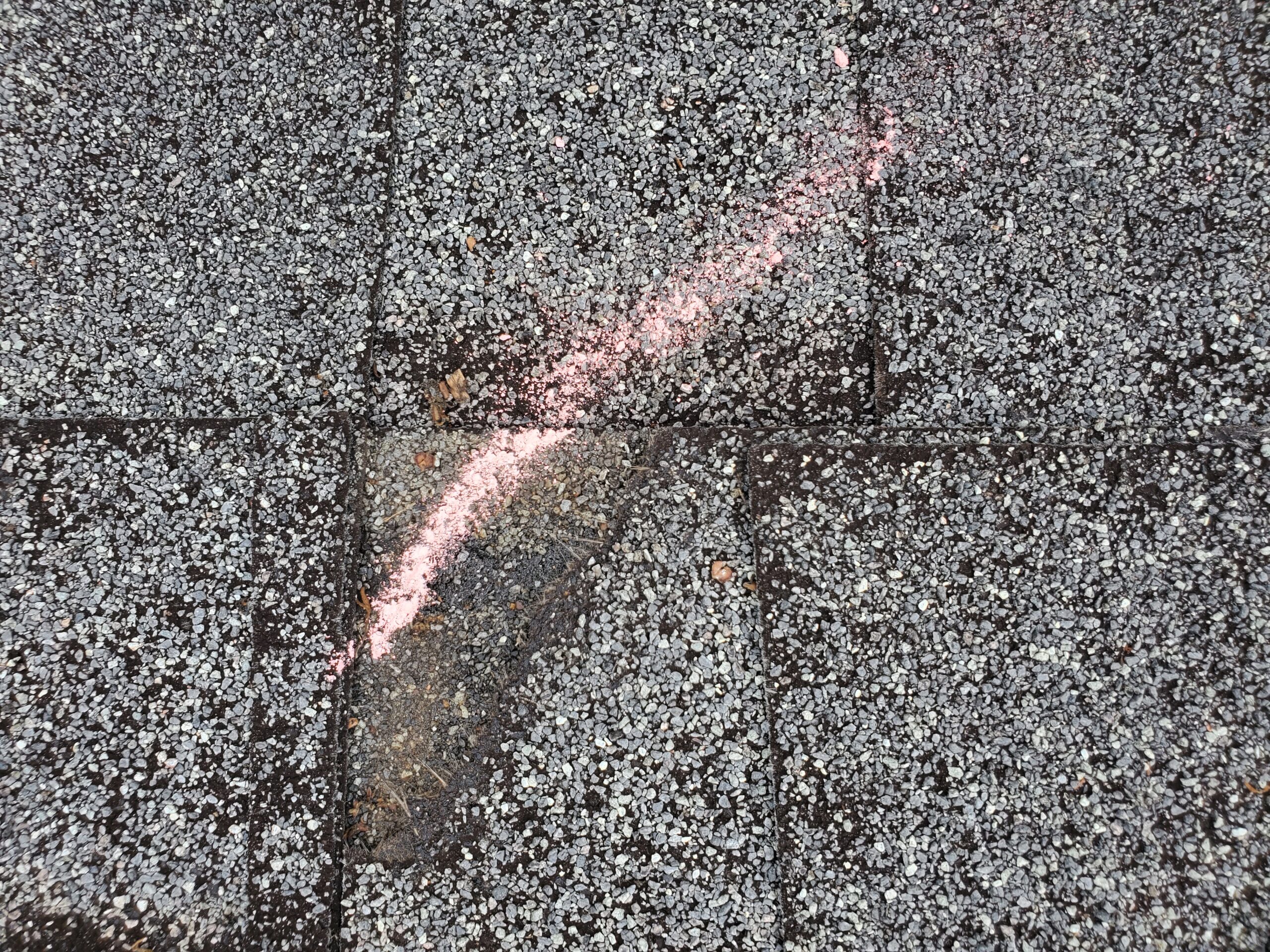 this is a picture of a chalk mark to the shingles where there is wind damages
