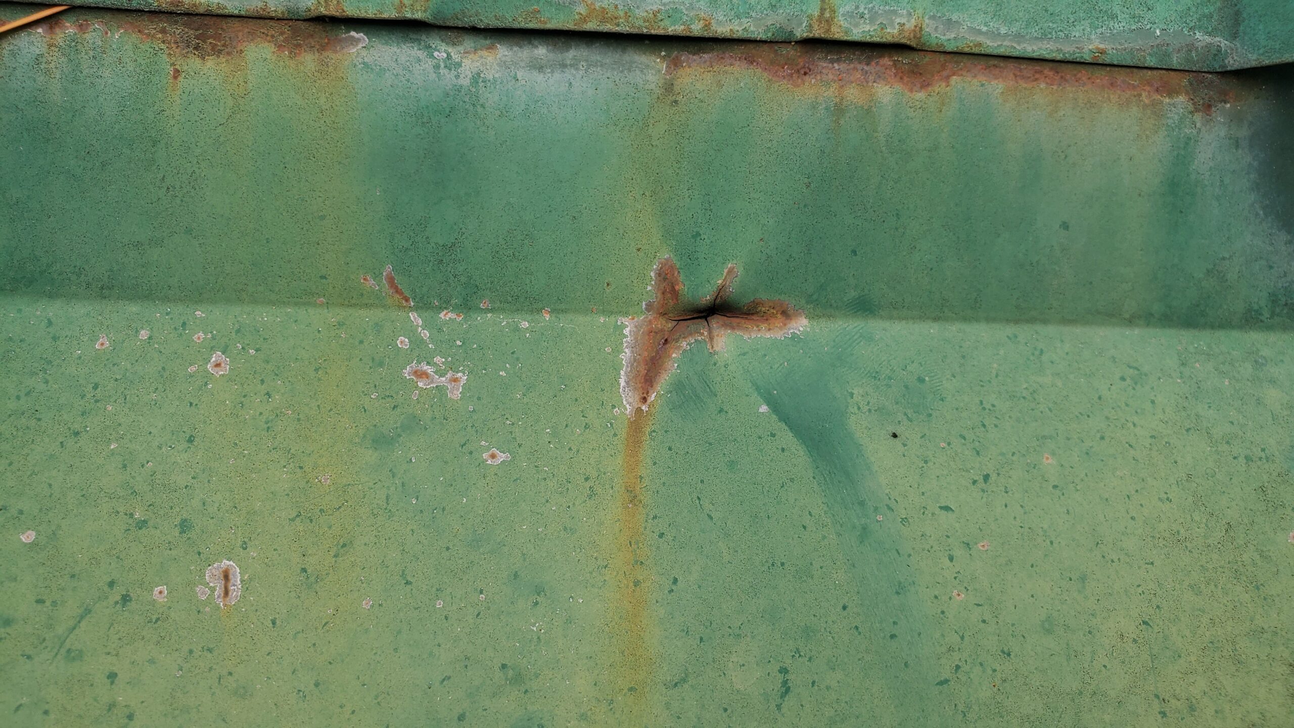 This is a view of a green metal roof with rust on the metal.