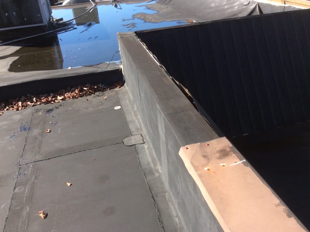This is a view of a commercial flat roof and wall with ponding water. 