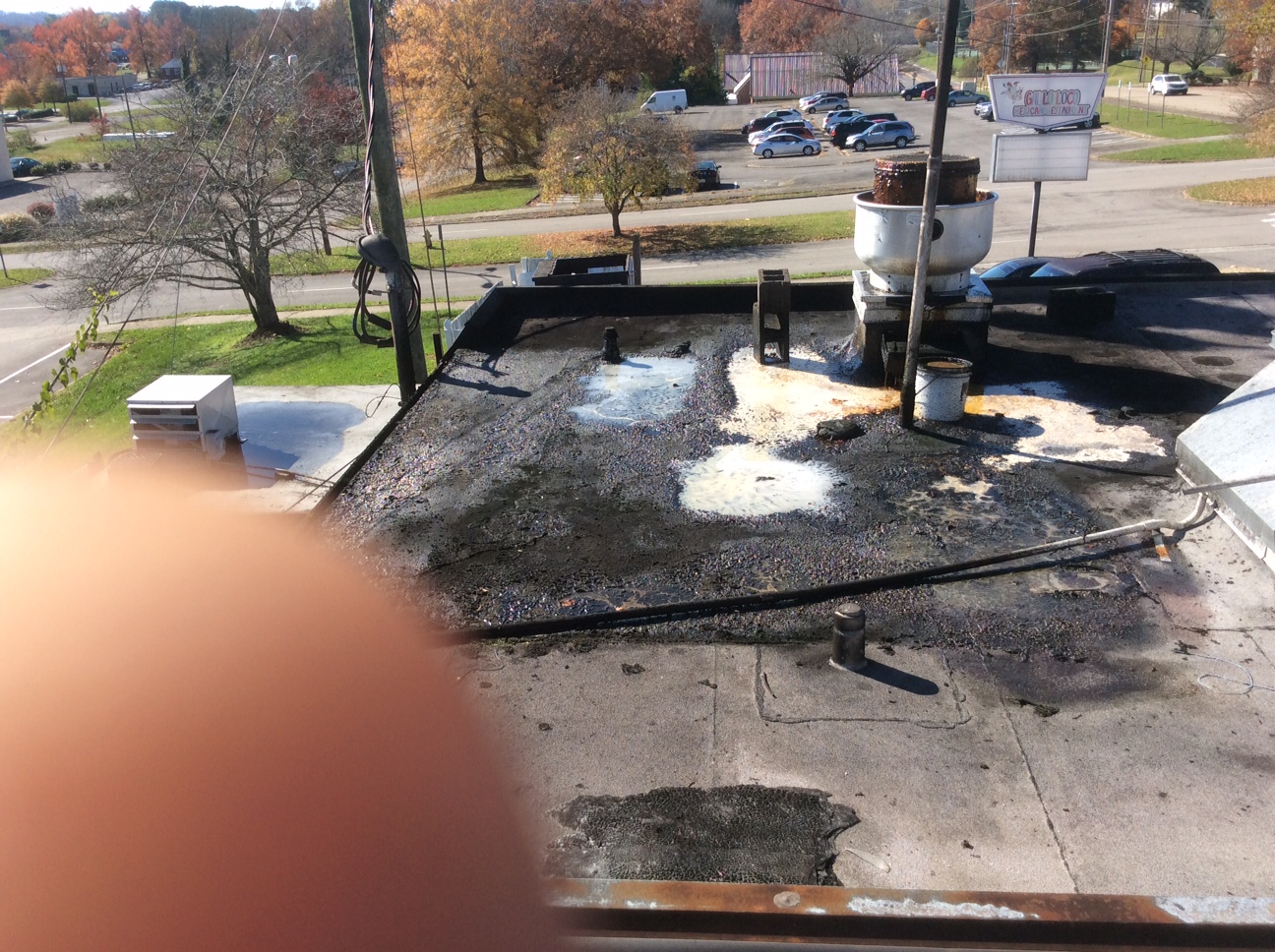 This is a view of a commercial flat roof with damaged areas.  