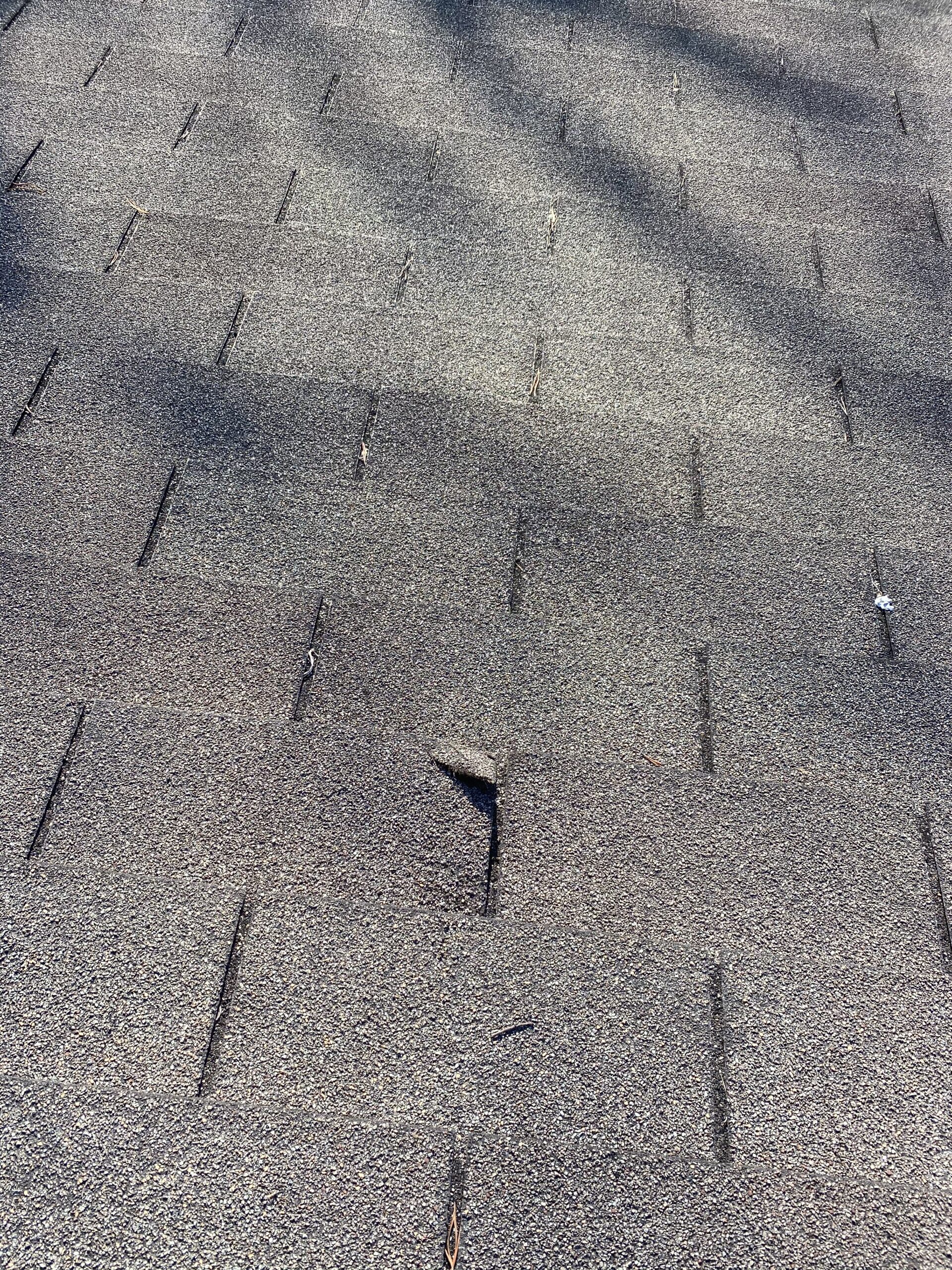 This is a picture of an old 3 tab shingle that has wind damage.