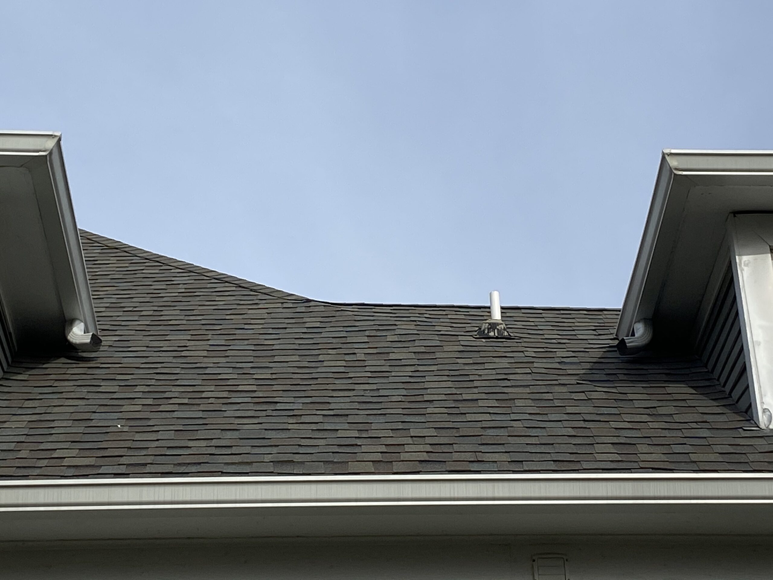 This is a picture of elbow downspouts that are pointed directly to the sides of the shingle