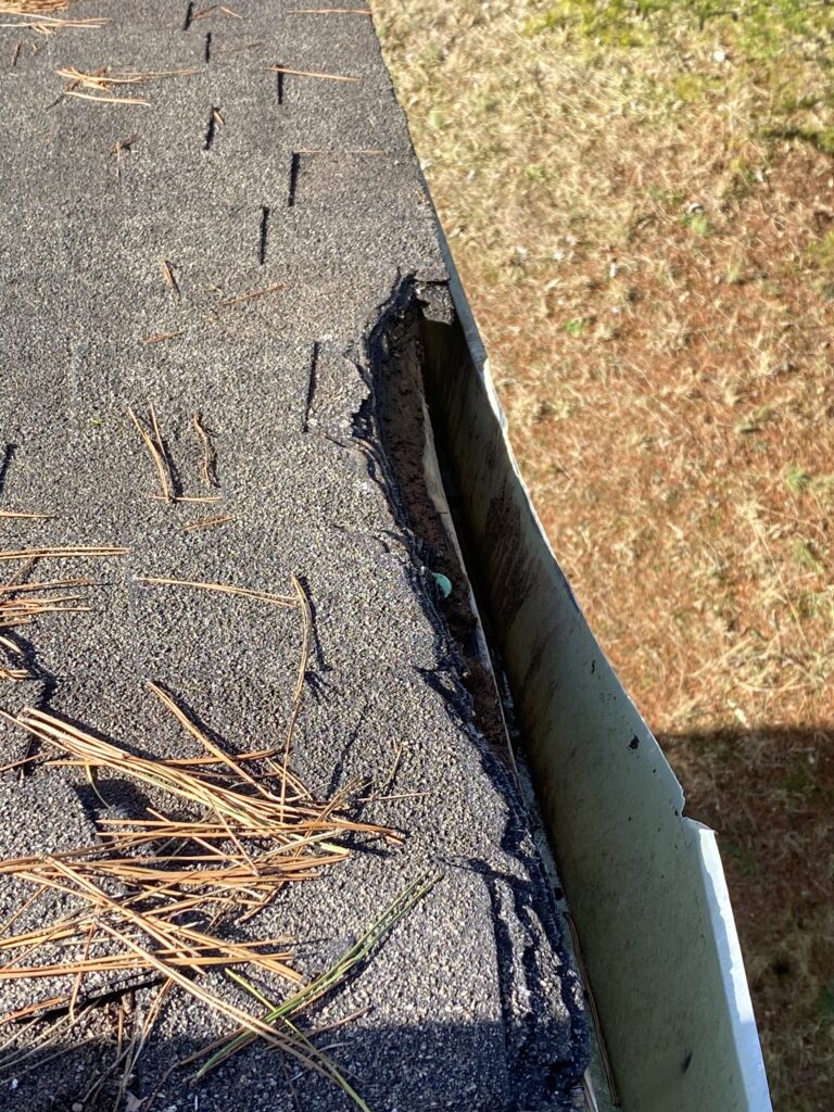 This is a picture of damaged  shingles and fascia metal