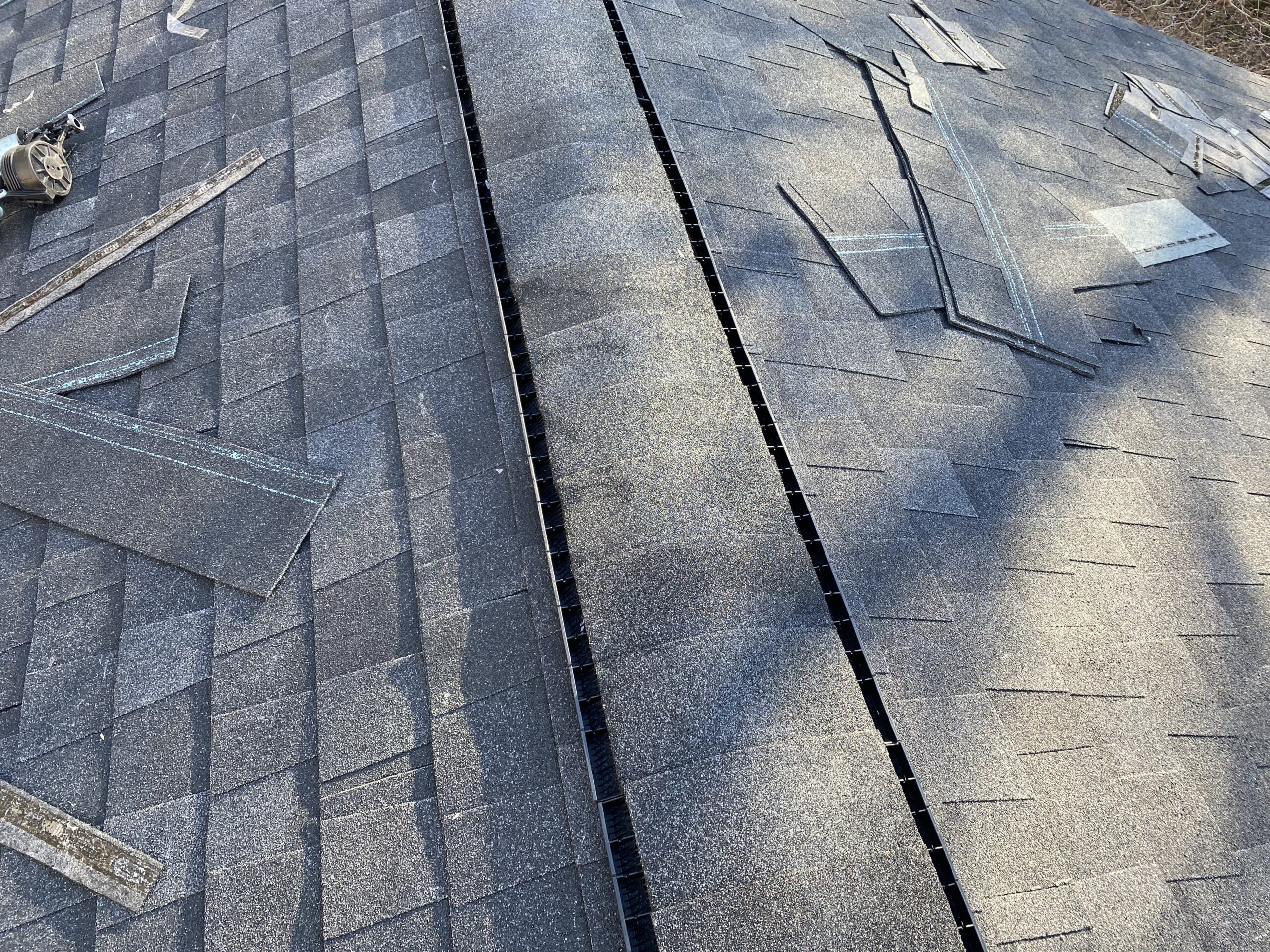 This is a picture of a ridge vent with charcoal black shingles