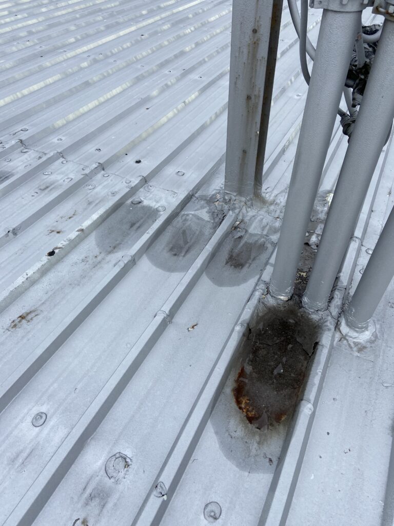 This is a picture of a gray roof that has metal roof screws that are leaking