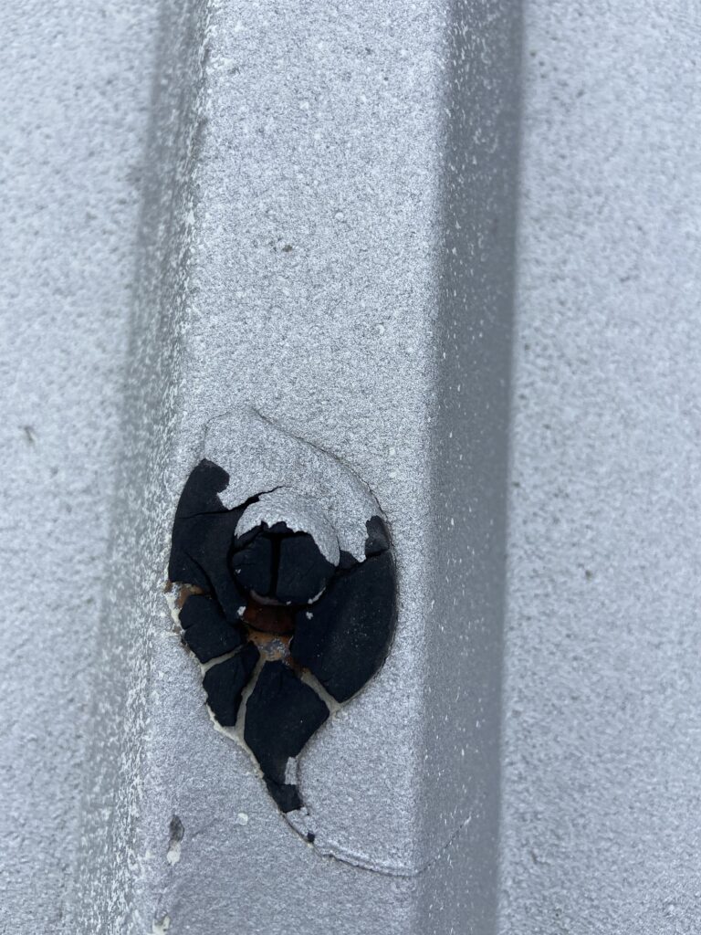 Coating on a metal roof screw that has been cracking in having problems and leaking