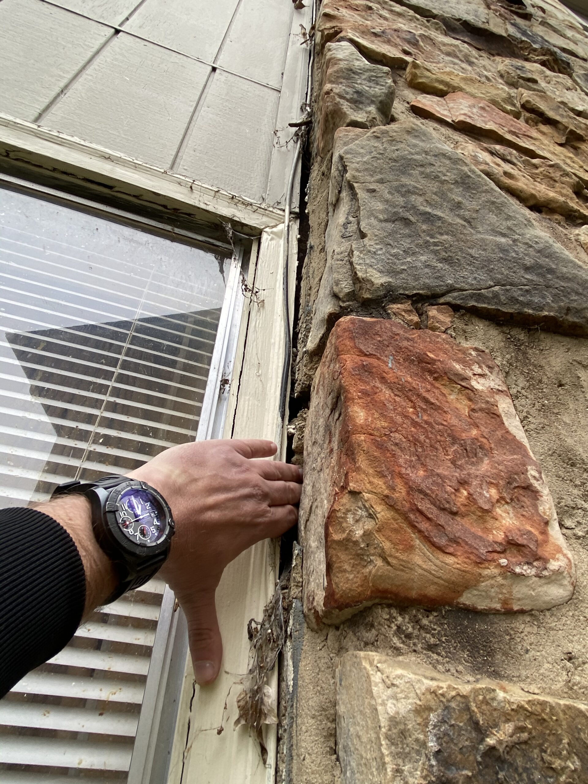 This is a picture of a stack stone wall next to a window where there is a big crack I can let water into this building in Knoxville Tennessee