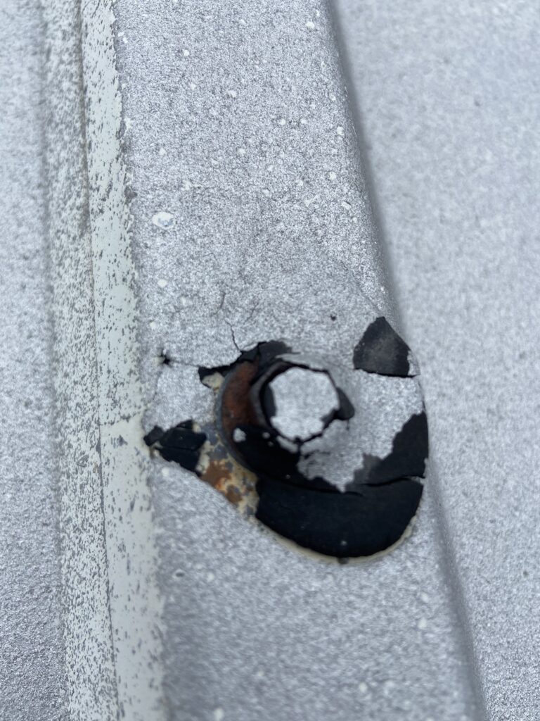 Metal roof screw that has been partially coded and is failing