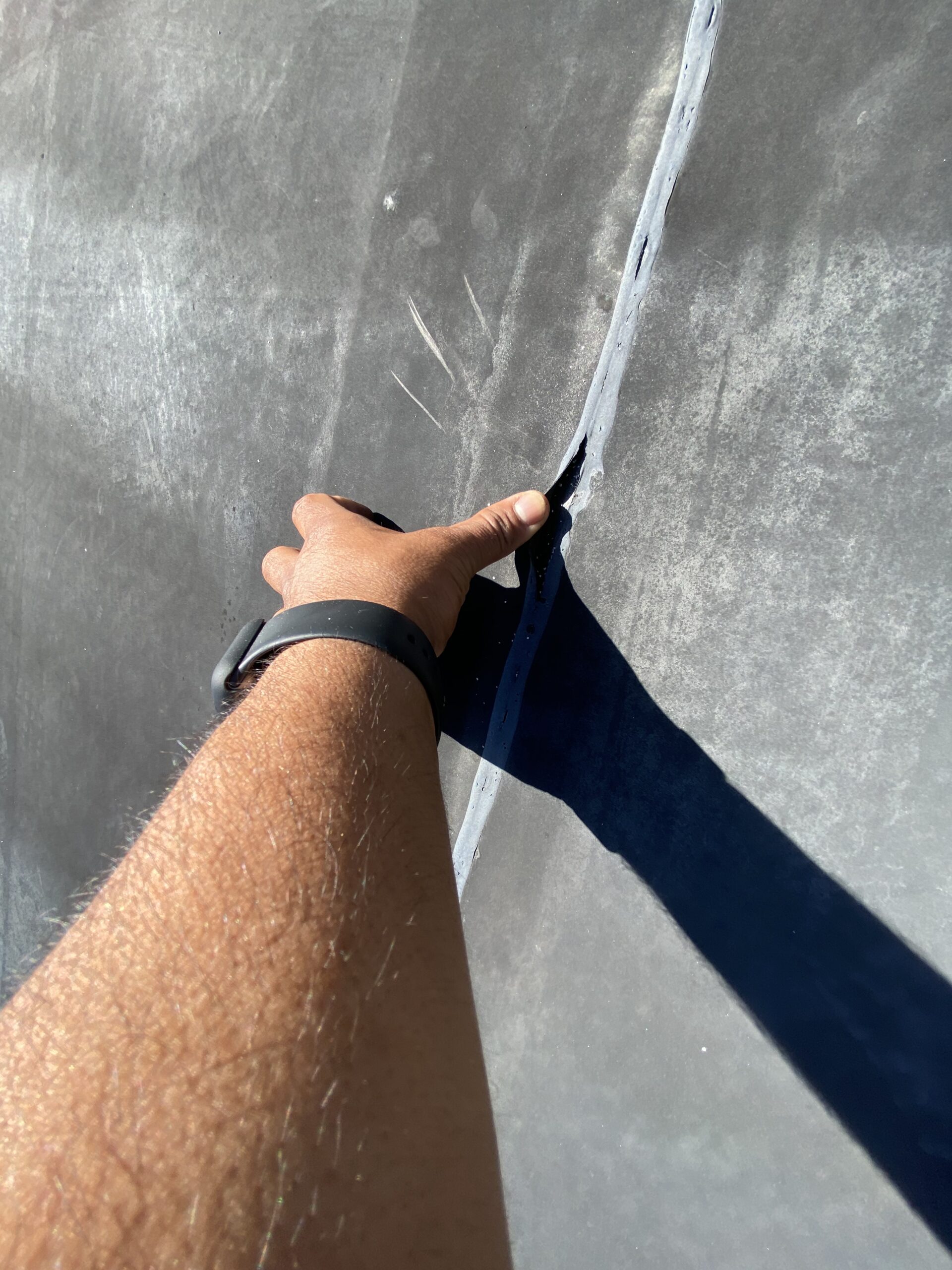 This is a picture of a seam that is coming up on a black flat roof