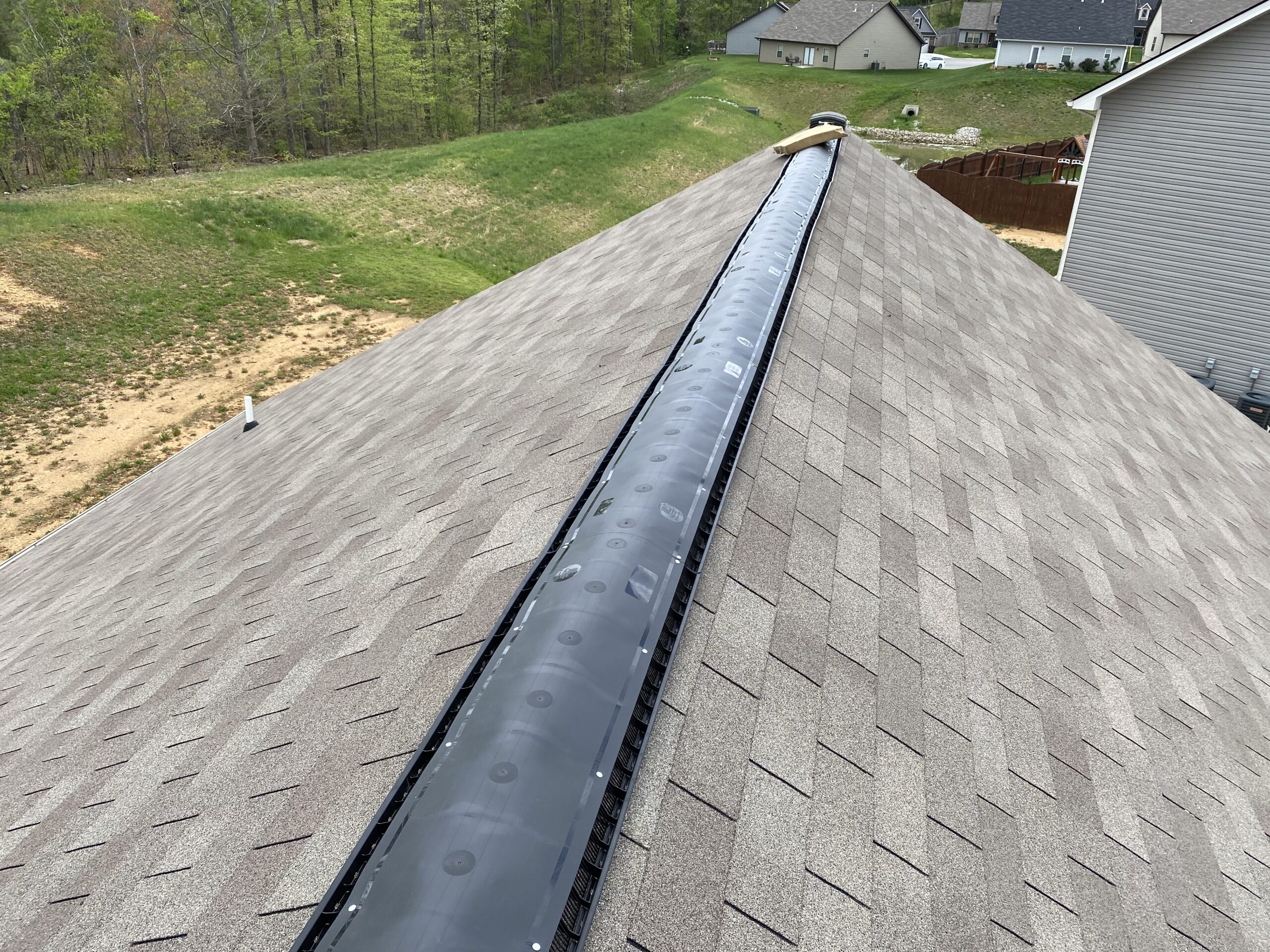 This is a picture of a black plastic ridge vent without shingles on it