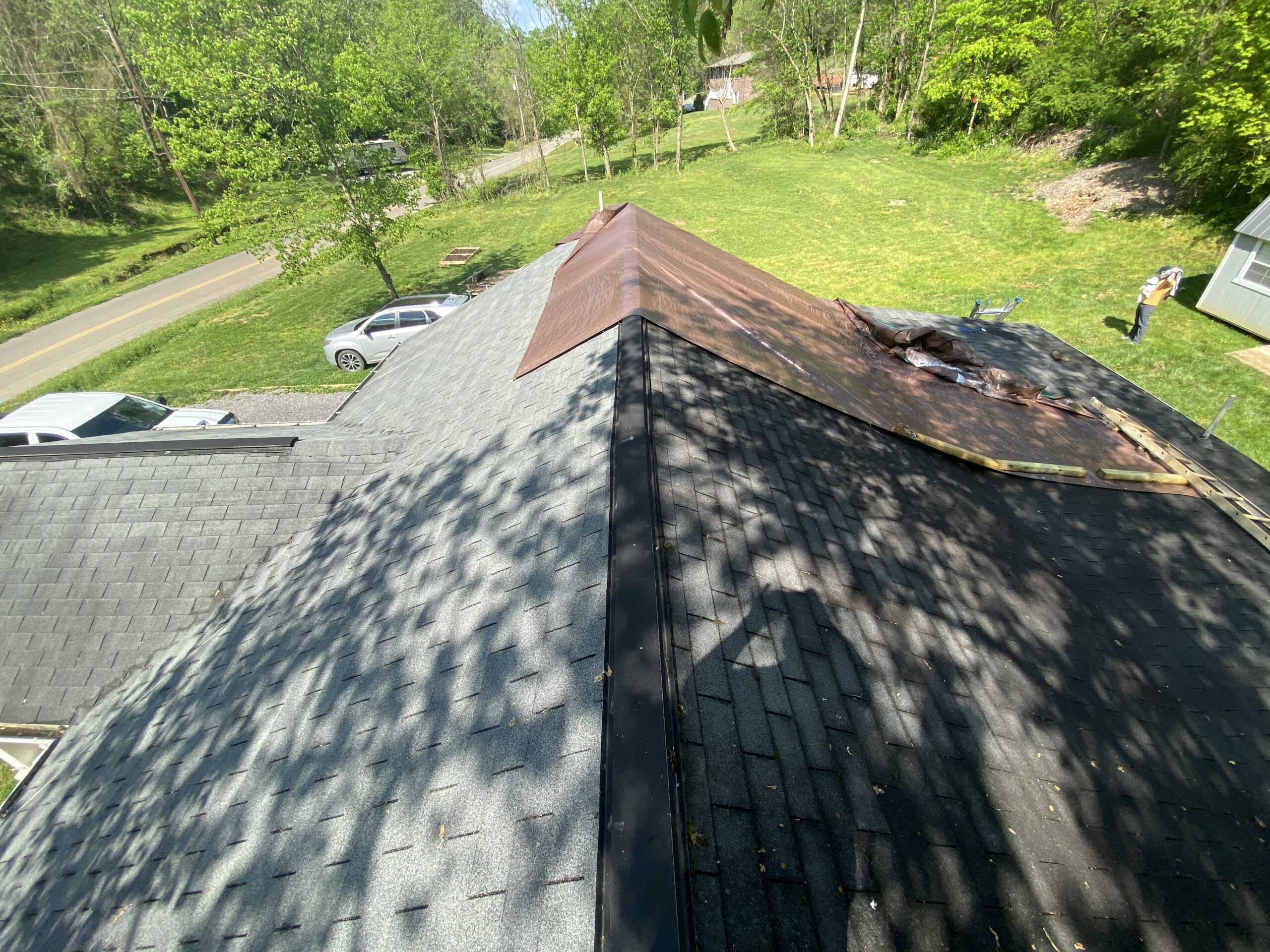 This is a picture of an old gray three tab roof with a brown tarp