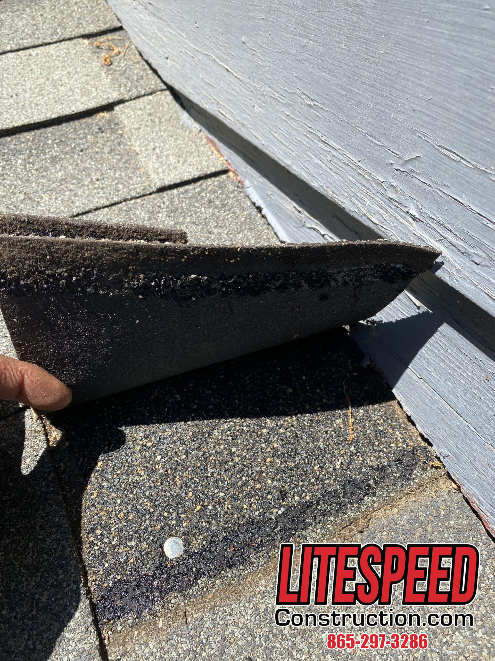 This is a picture of a lifted shingle at a wall with no step flashing underneath