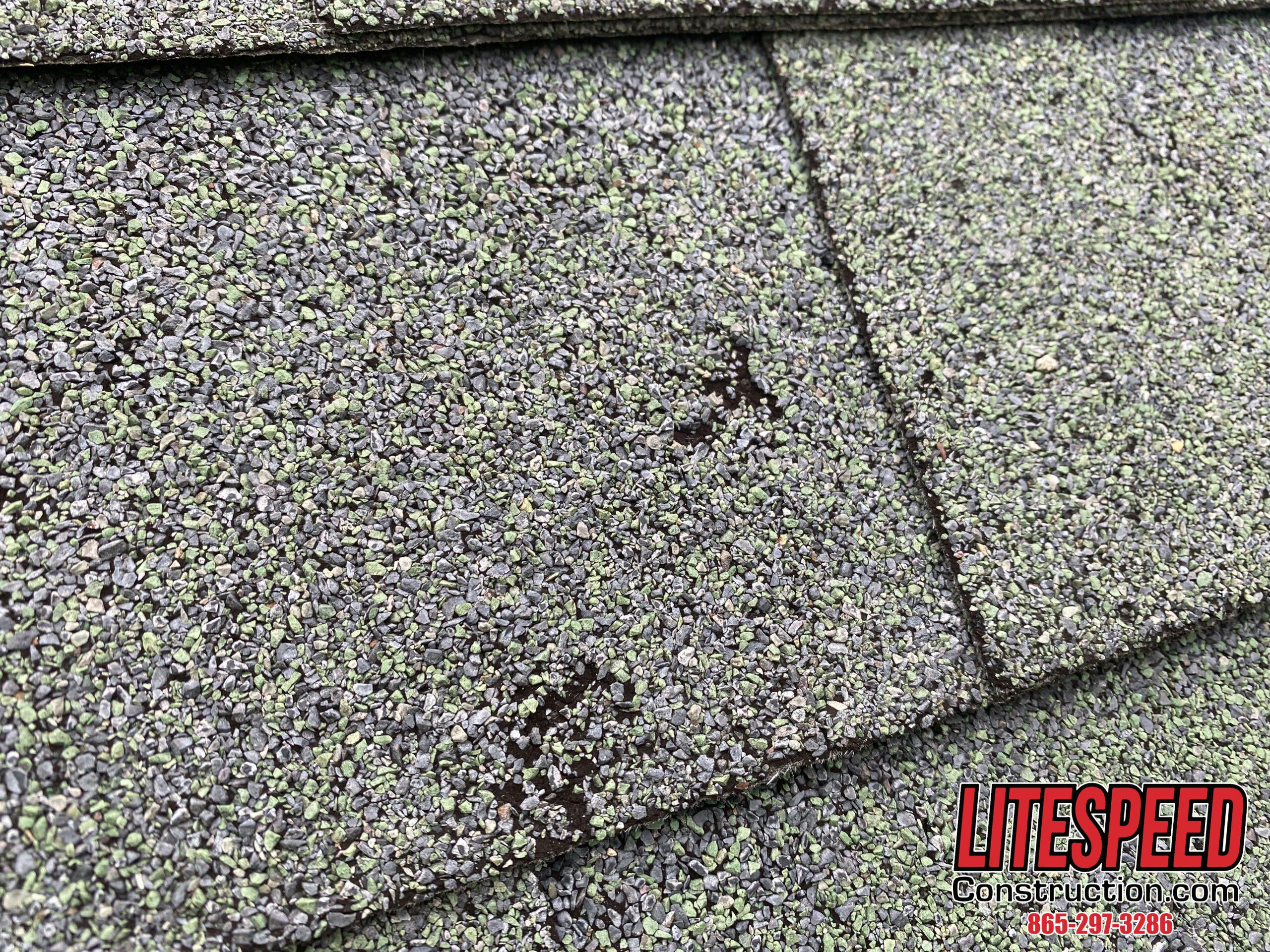 This is a picture of a green shingle with hail damage all over the roof.