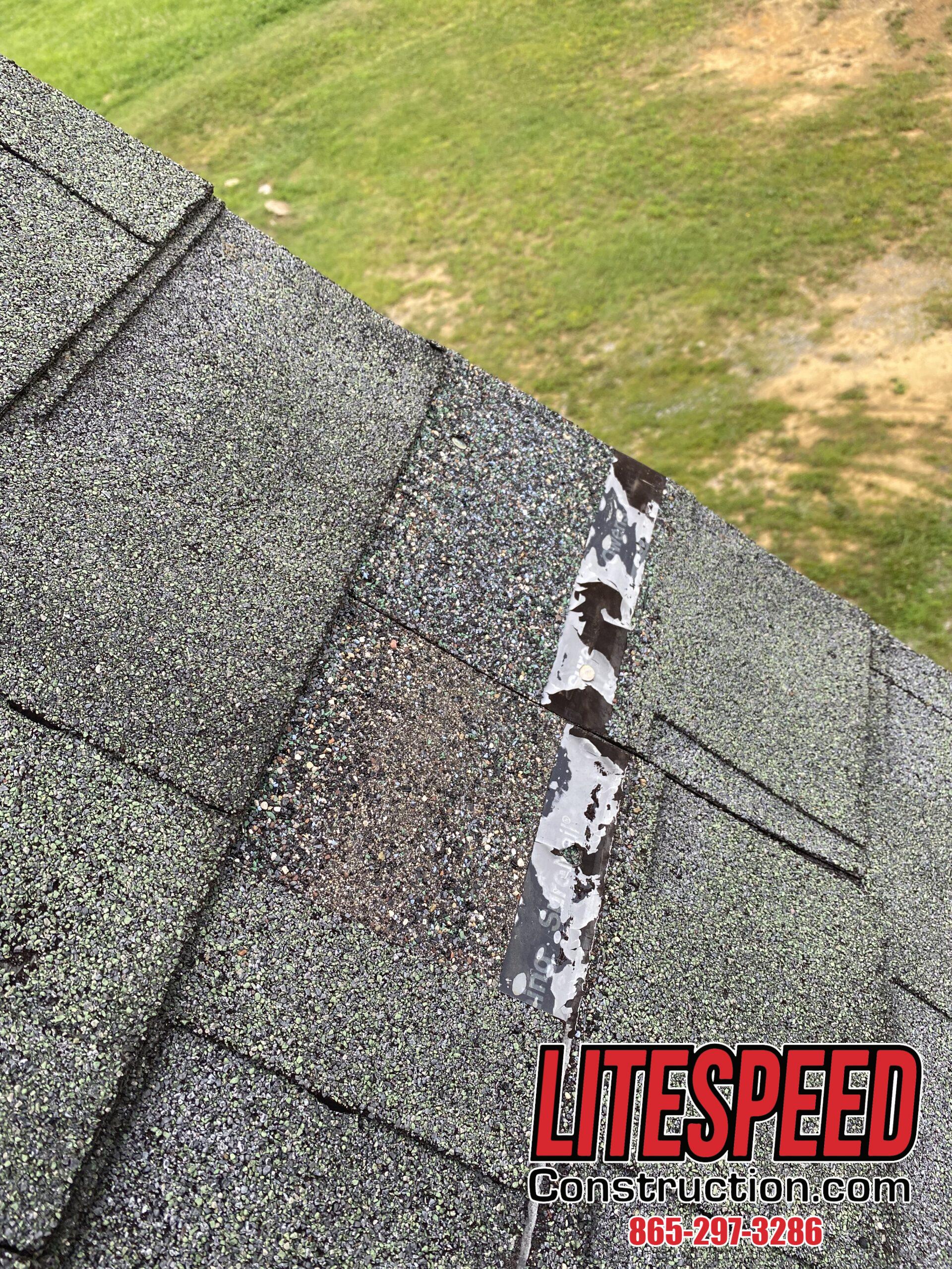This is a picture of a green roof with missing and broken shingles.
