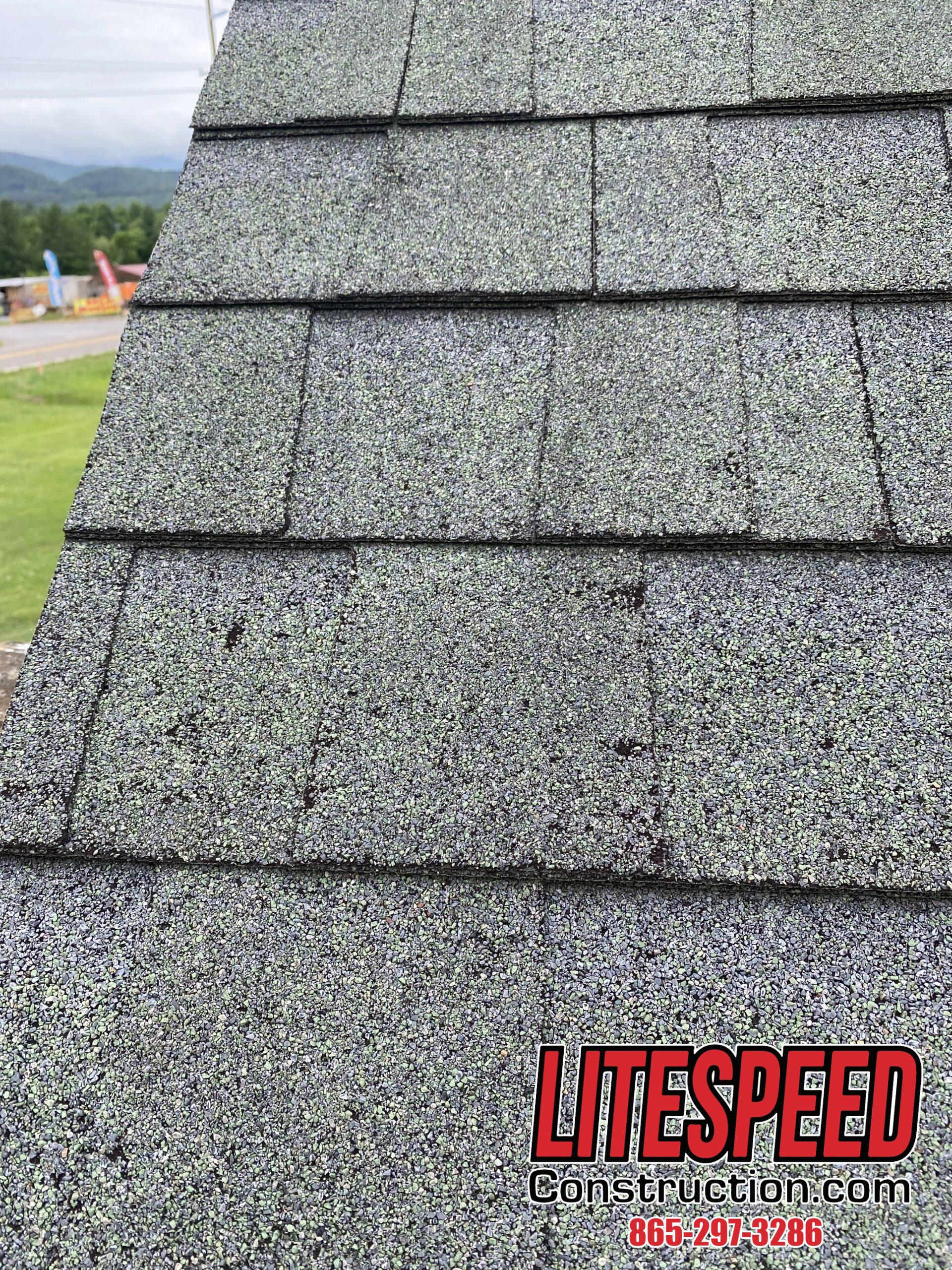 This is a picture of a green shingle with hail damage all over the roof.