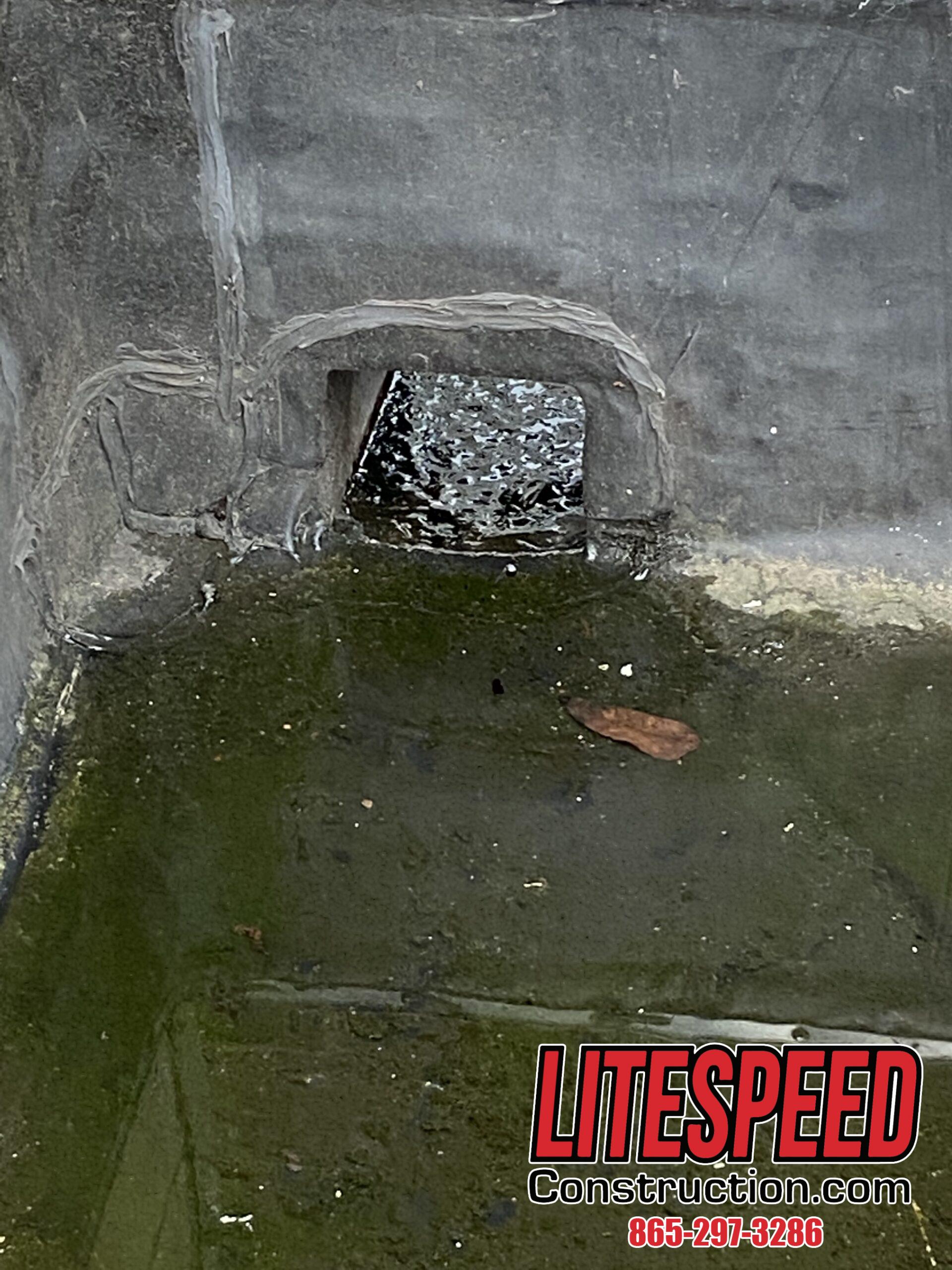 Scupper drain with standing water on a commercial roof