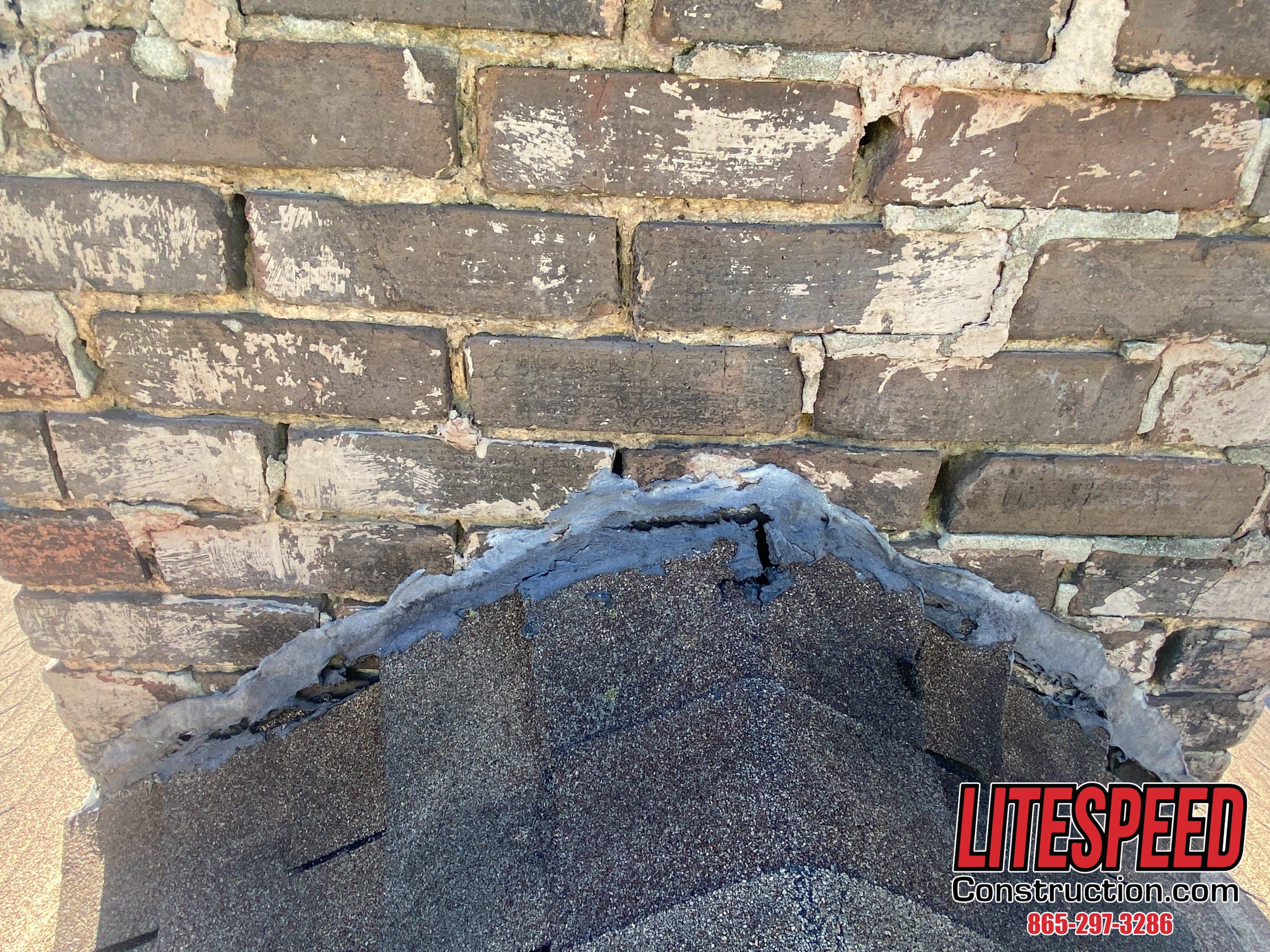 This is a picture of a chimney with no flashing at the shingles