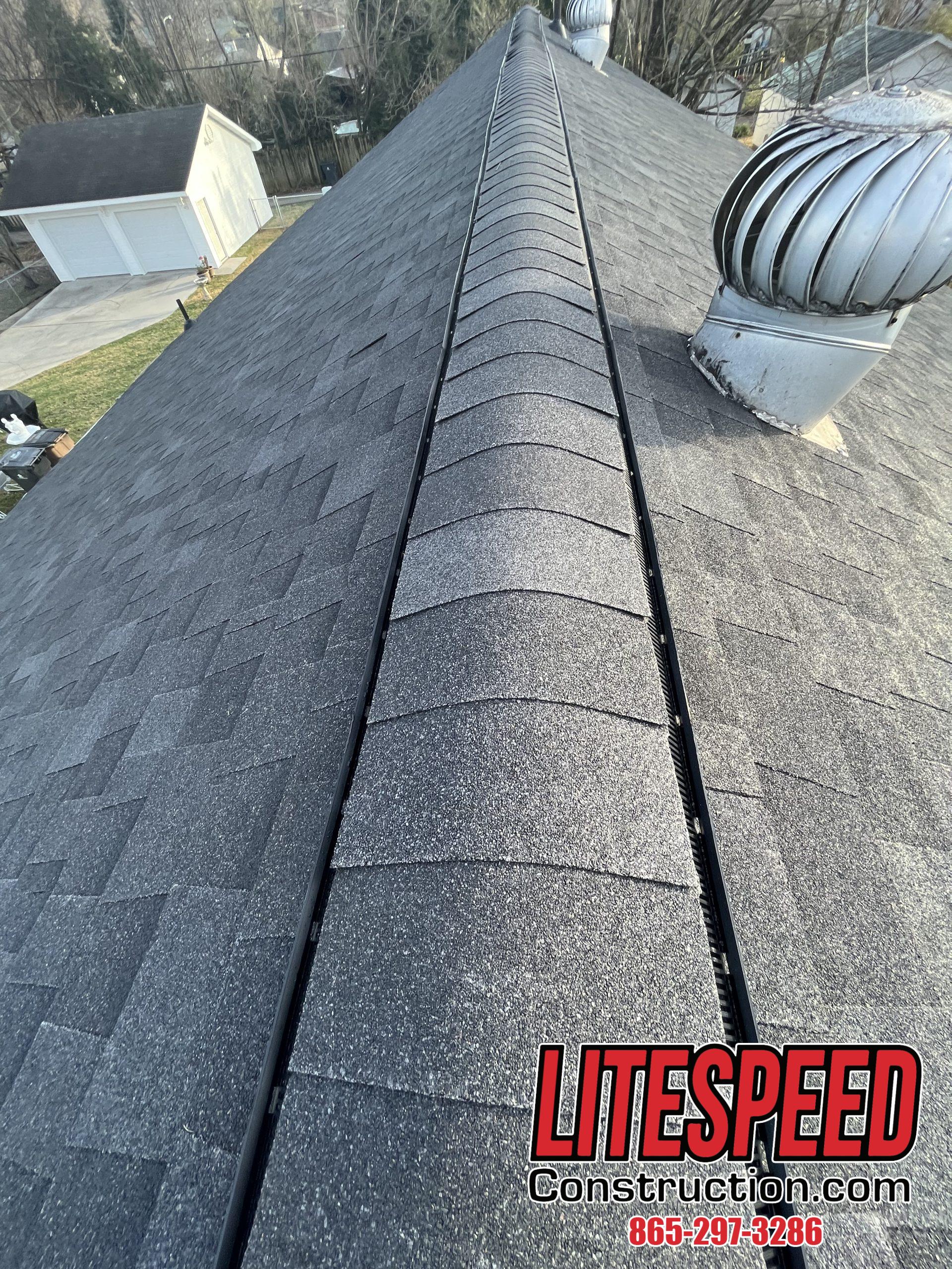 This is a picture of a ridge vent with black shingles