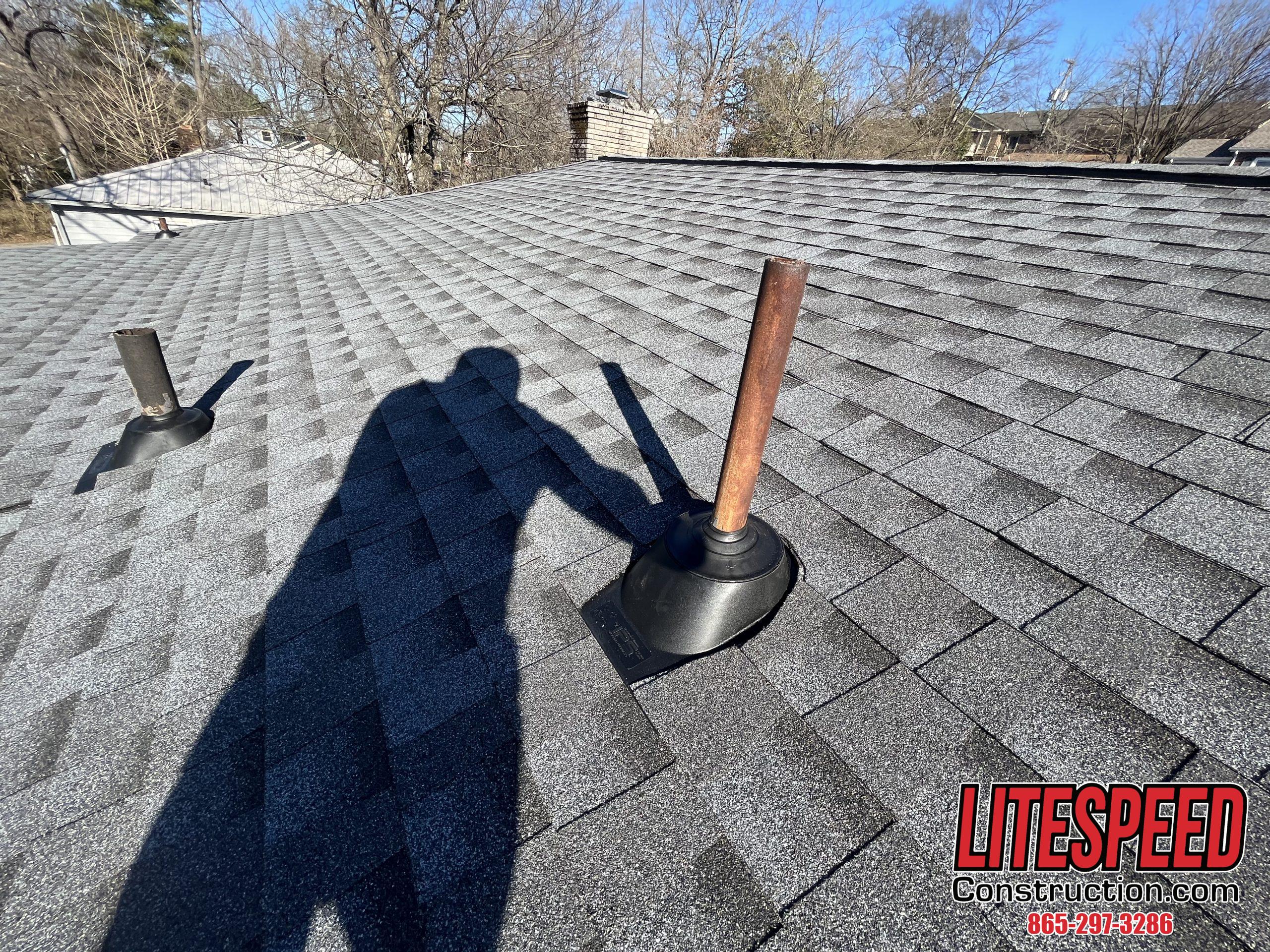 This is a picture of a pipe boot on a gray shingle roof