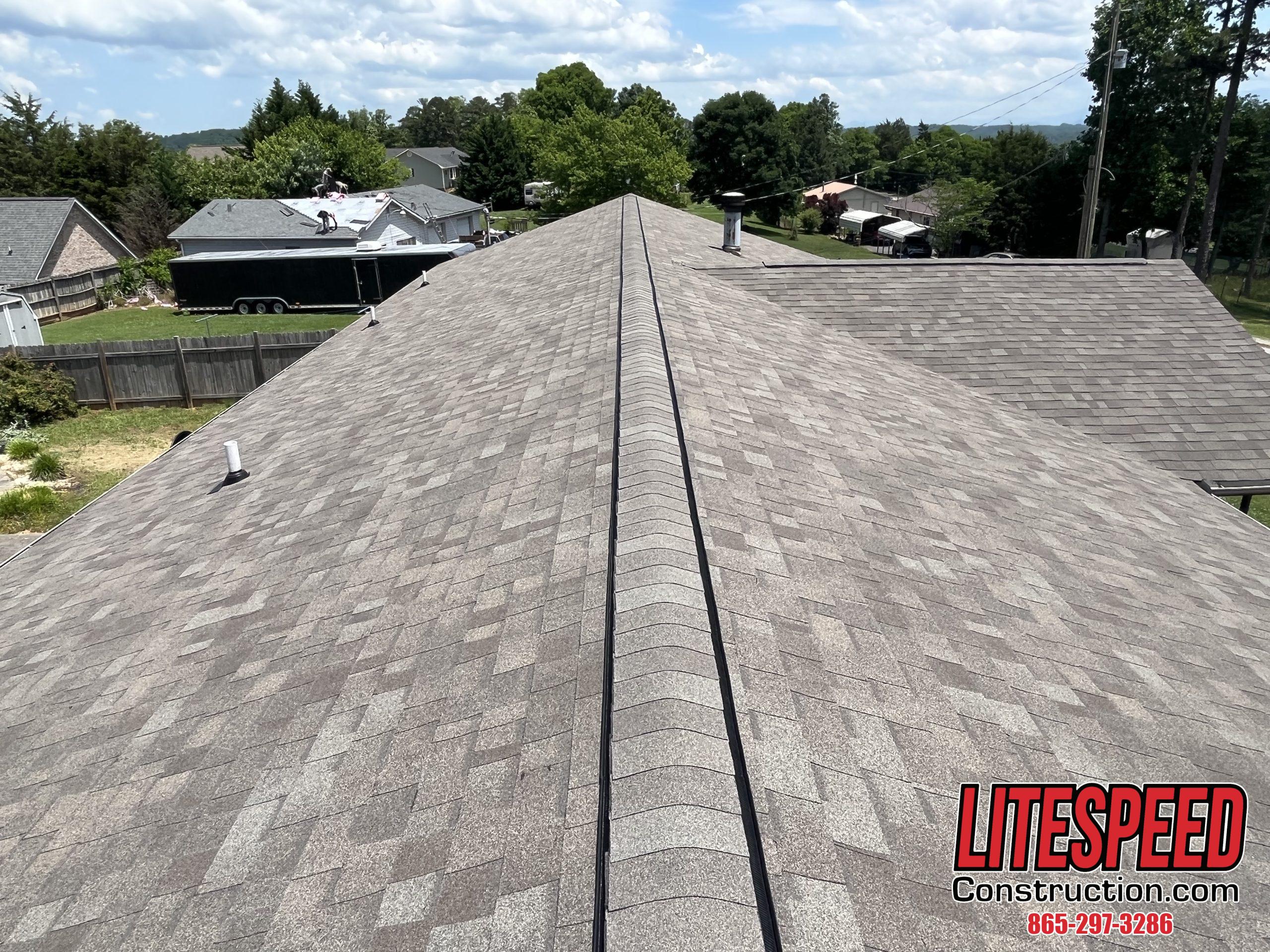 This is a picture of a new roof with light brown shingles