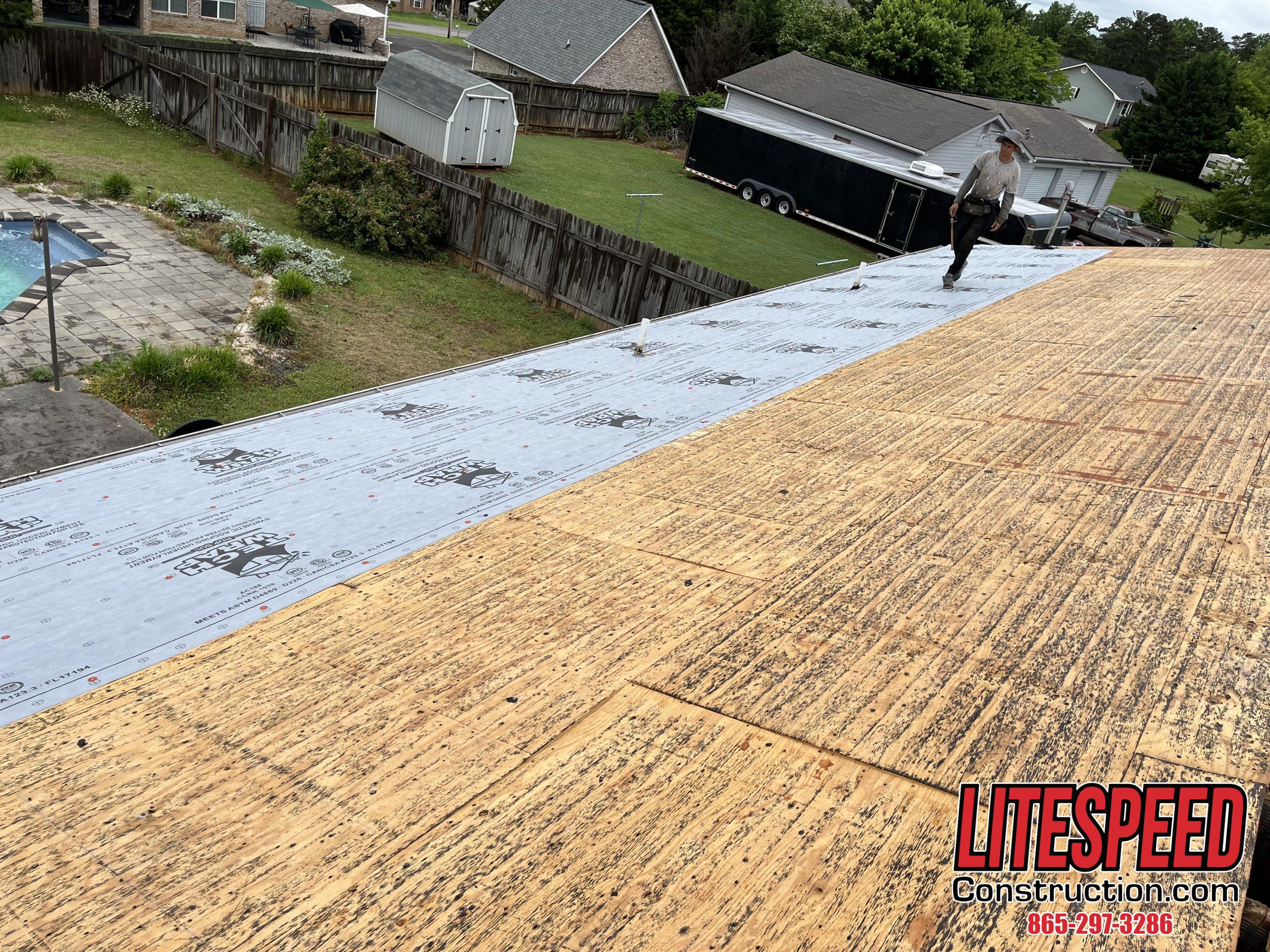 This is a picture of synthetic underlayment being laid down on a roof