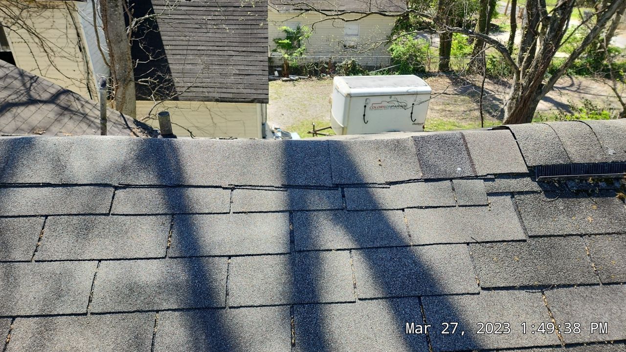 Warped and bent shingles on the ridge line