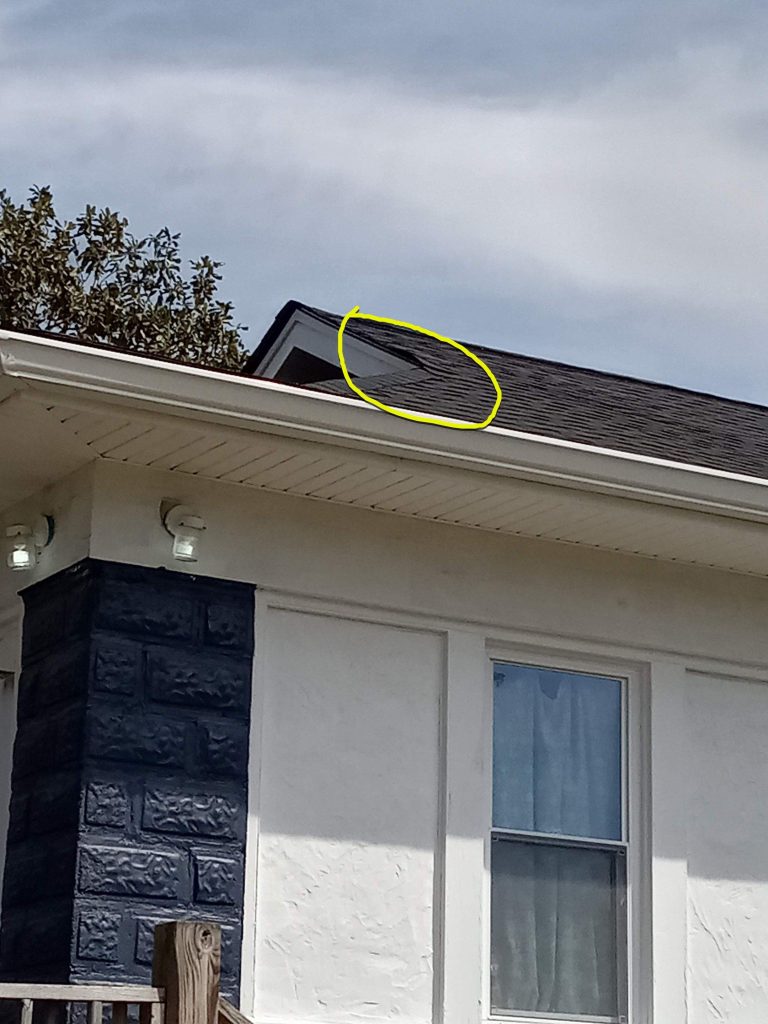 Photos show buckled and lifted shingles on the corner of the house.