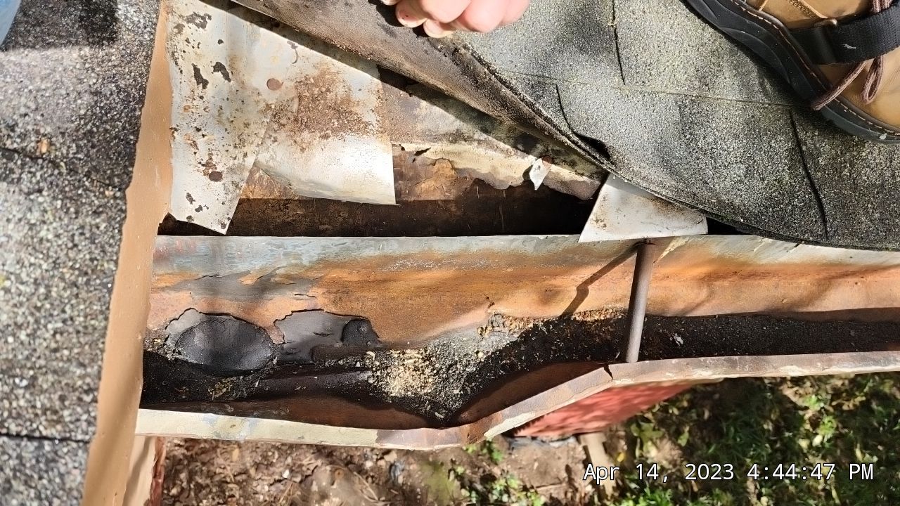 Damaged and warped gutter below rotten boards