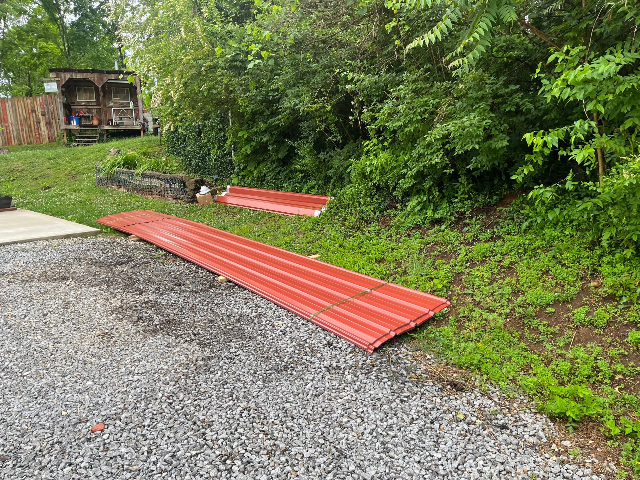 Corrugated metal roofing sheets in Barn Red color.