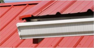 Photo of red metal roof with eave and gable flashing.