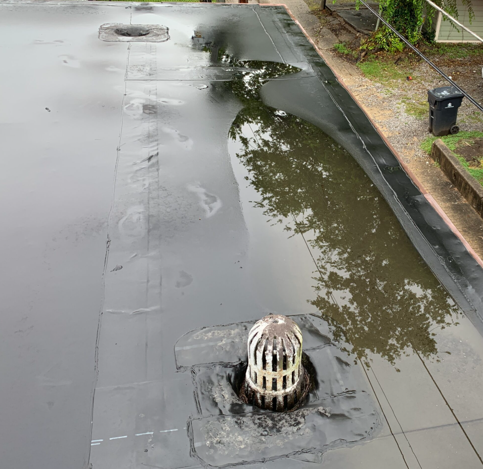 flat commercial roof drainage, roofing maintenance Knoxville TN, commercial roof water pooling, roof ponding causes, EPDM roof ponding, how to fix flat roof ponding, water pooling on commercial roofs, commercial roof drainage system, flat roof design tips, commercial roof maintenance, roof water damage prevention, commercial building roofing solutions, flat roof slope standards, water pooling flat roof risks, Litespeed Construction Knoxville