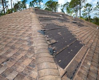 Wind and storm damage on a shingle roof.